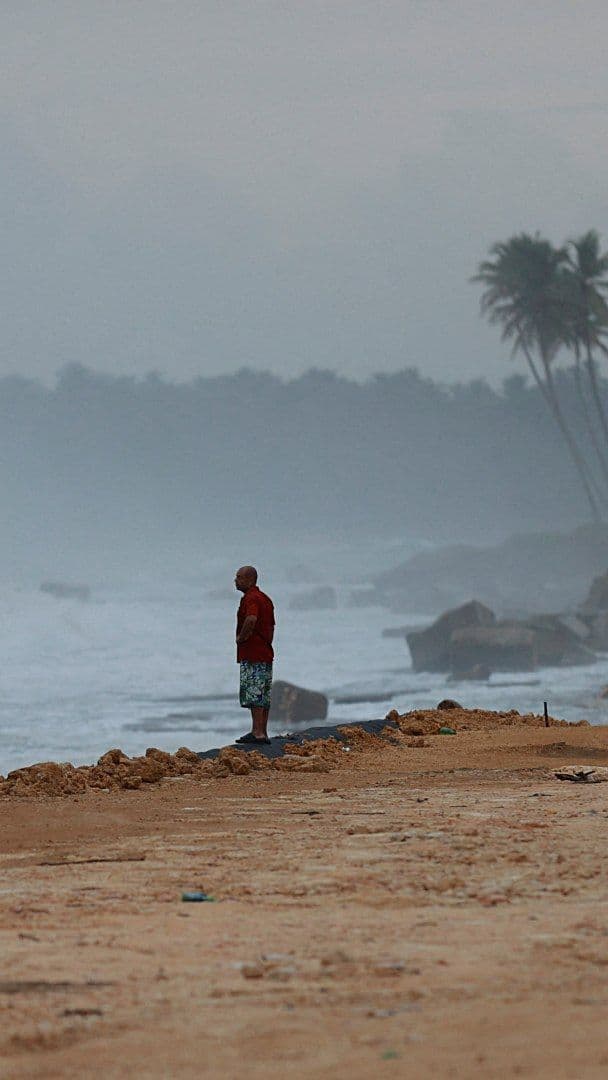 Un hombre permanece de pie en una playa de República Dominicana tras el paso del huracán Erin en agosto 2025.
