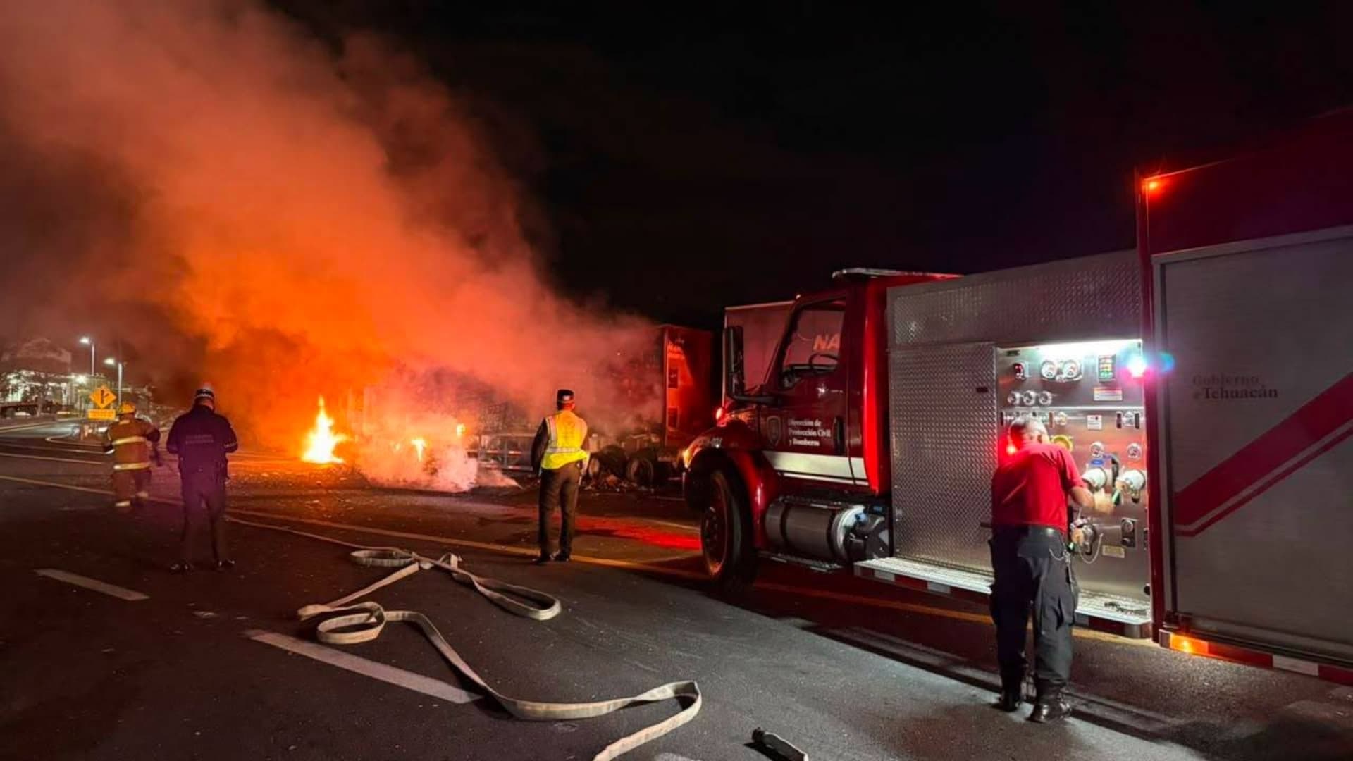 Cuerpos de emergencia combaten el incendio de la unidad de carga.
