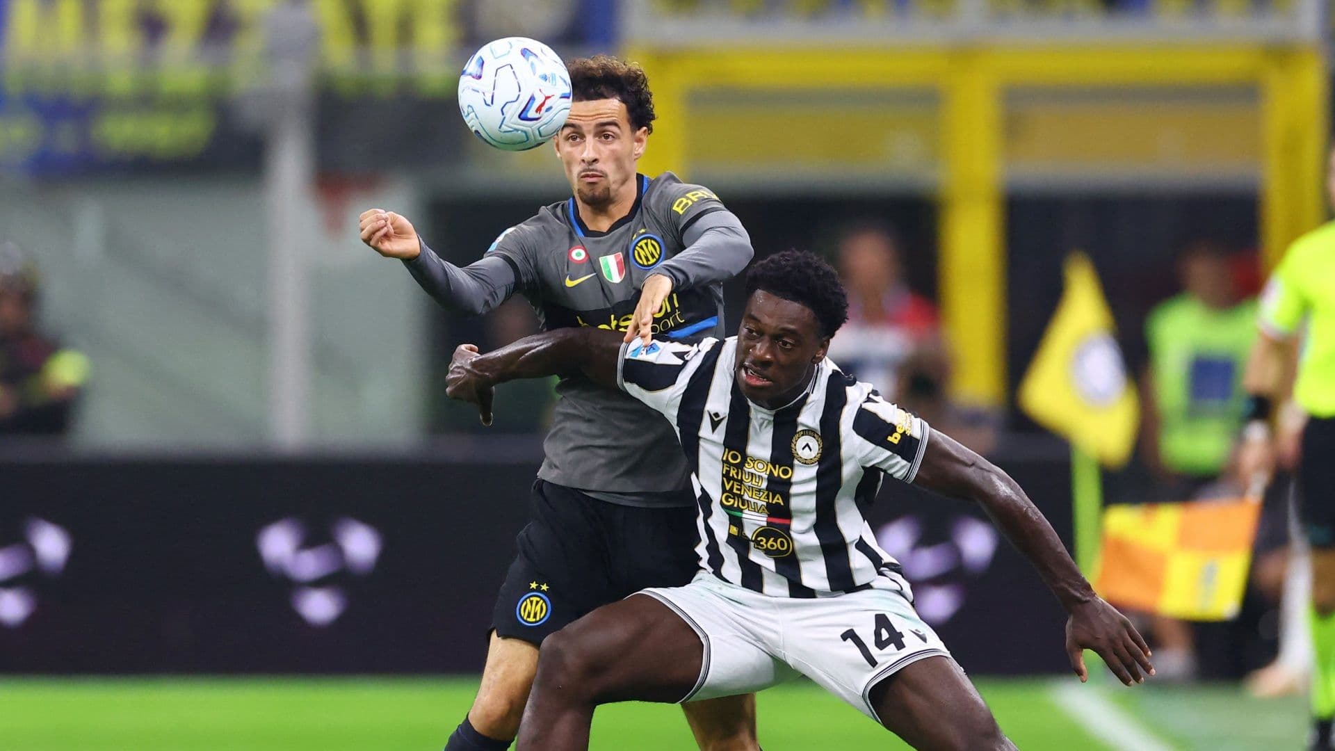 Curtis Jones, del Milán, disputa la pelota con James Abankwah, del Udinese, en el Estadio San Siro.