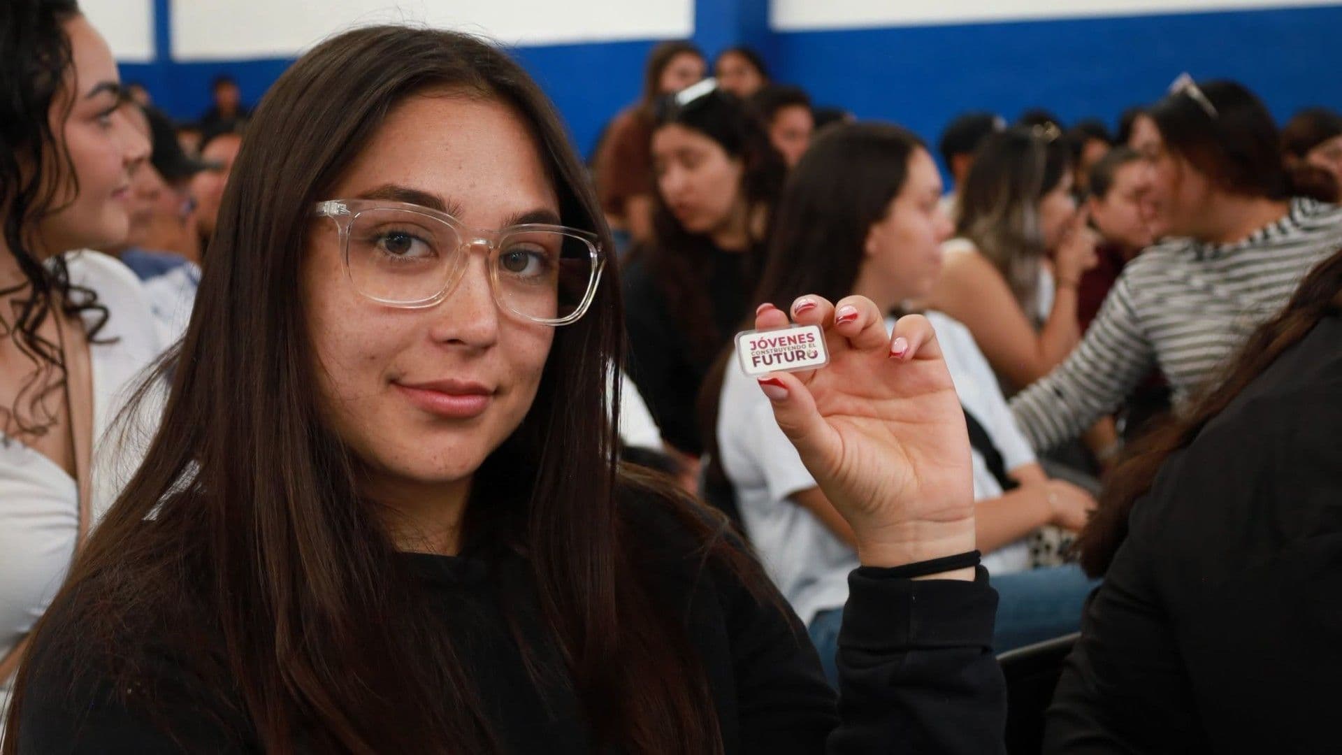 Mujer sostiene pin con logo de JCF. Cuándo abre plataforma y por cuánto tiempo recibes apoyo de 9.500 pesos.