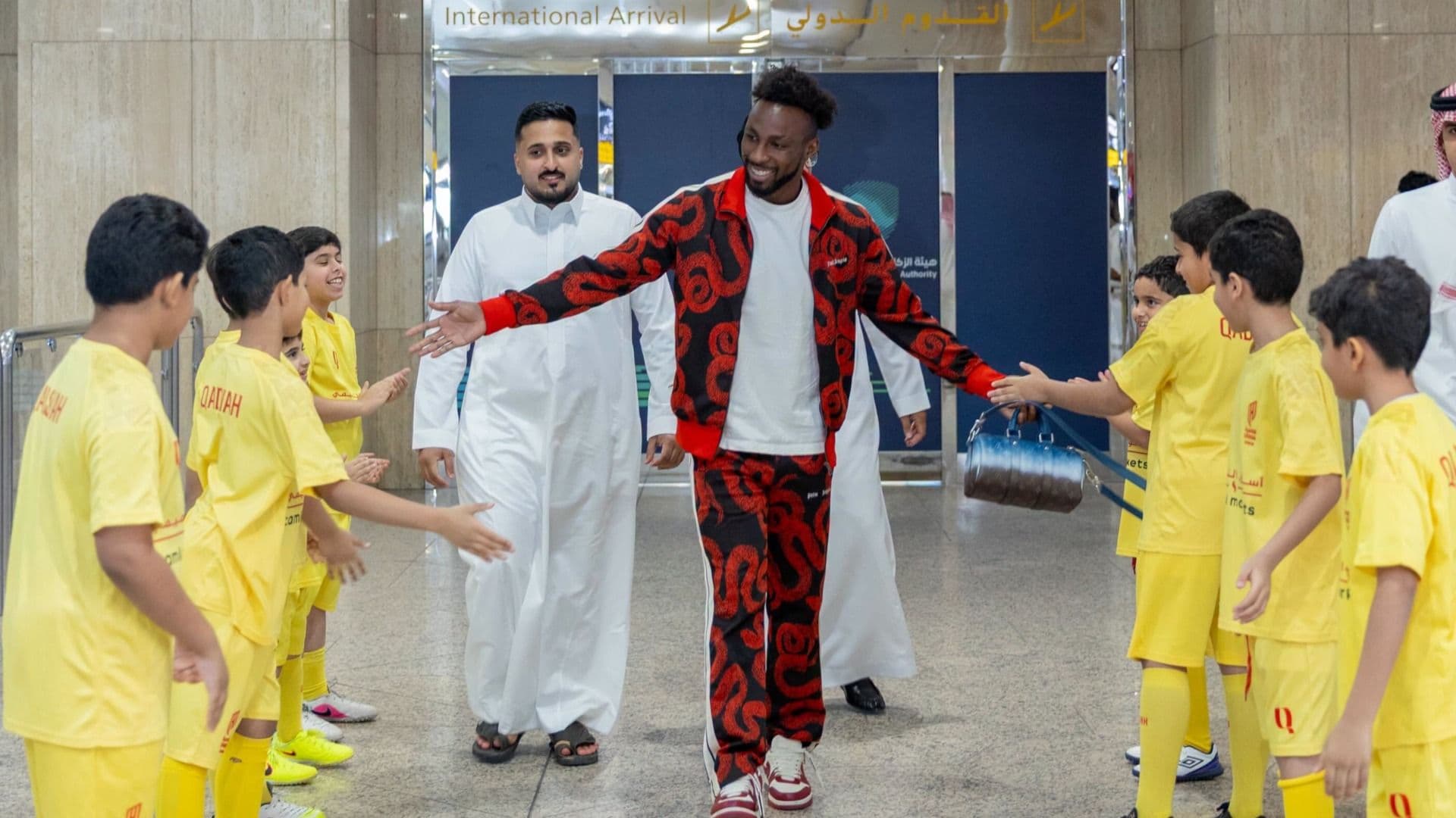 Julián Quiñones saluda a varios pequeños en el Aeropuerto Internacional Rey Fahd.