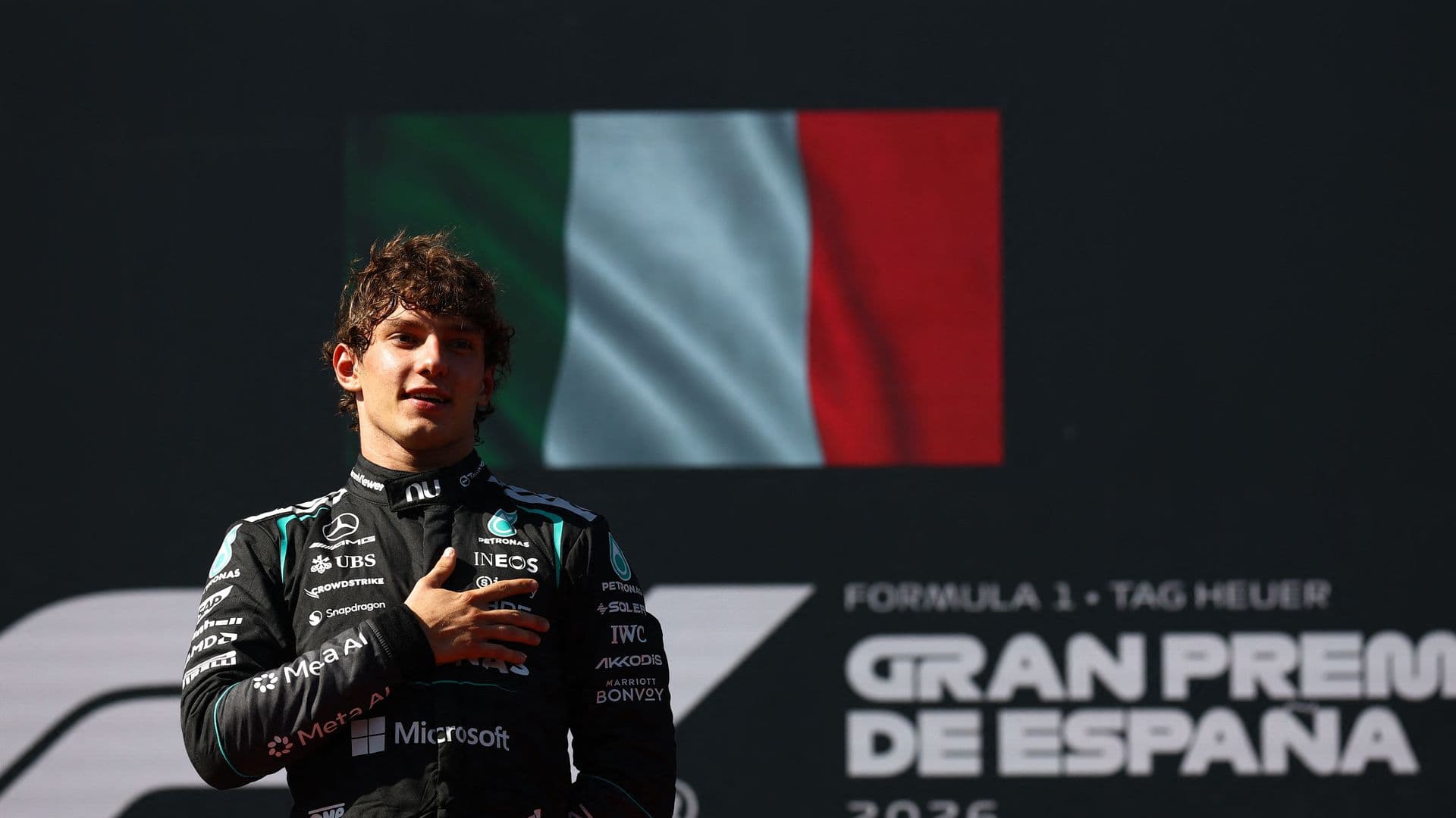 Kimi Antonelli pone la mano en su pecho sobre el podio, tras ganar el GP de España 2026
