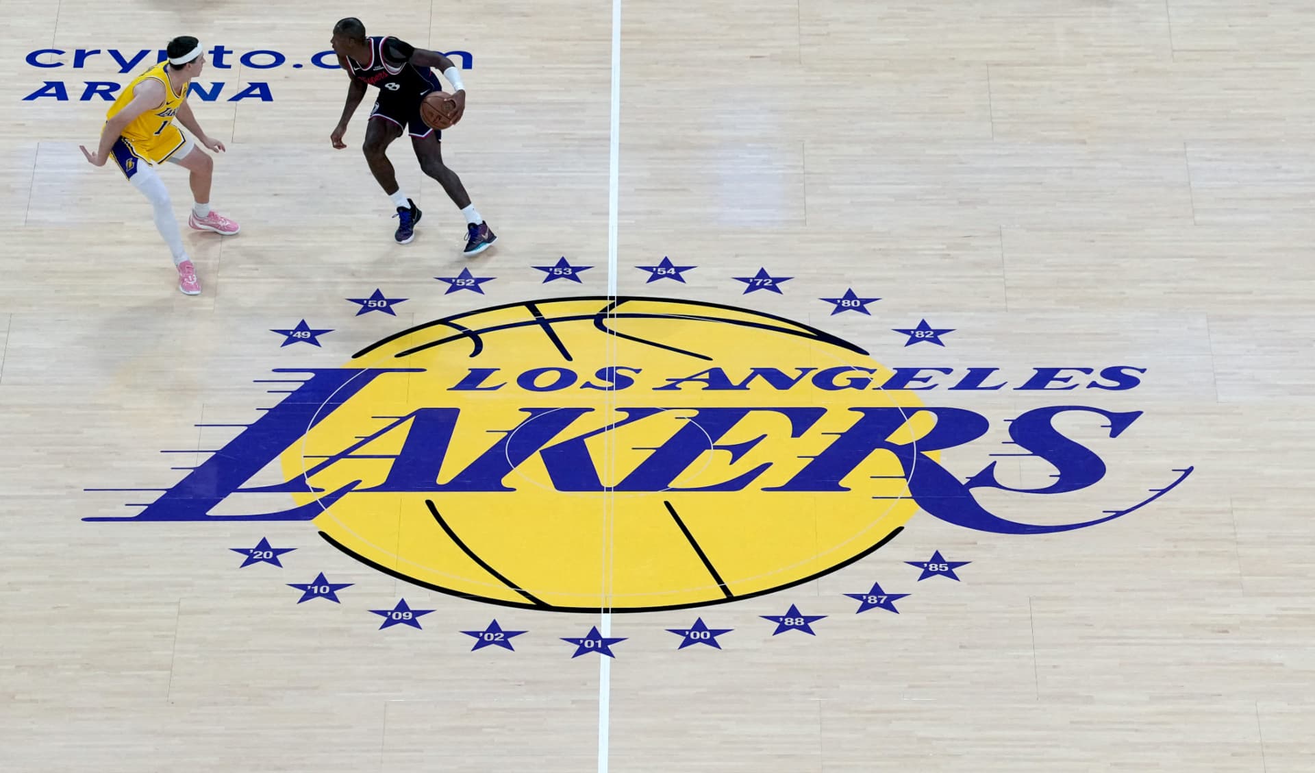Kris Dunn de los Clippers frente a Austin Reaves de Los Ángeles, sobre el logotipo de los Lakers.