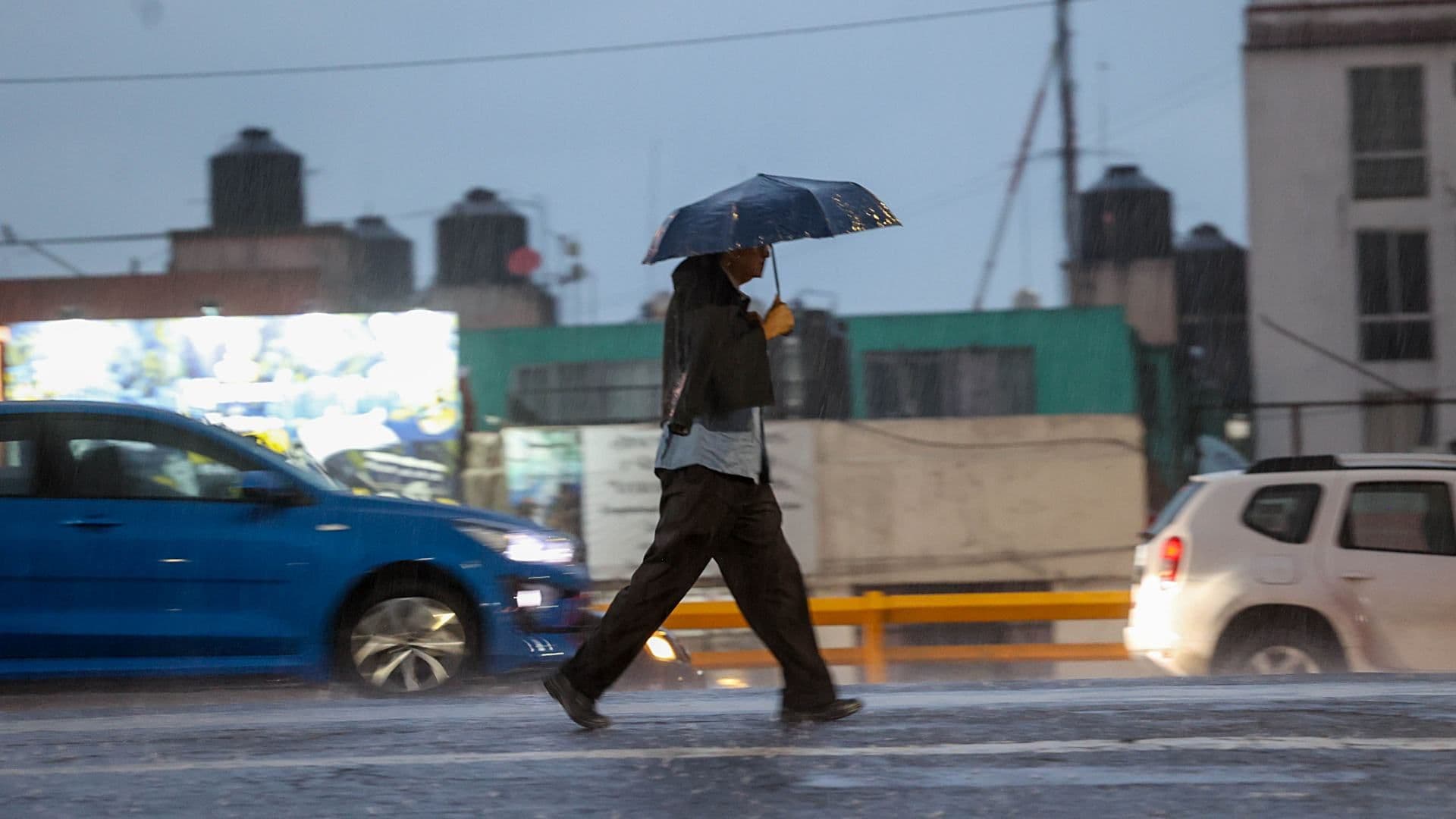 Una persona se protege con un paraguas de la fuerte lluvia en CDMX en agosto 2026. Foto: Cuartoscuro | Archivo