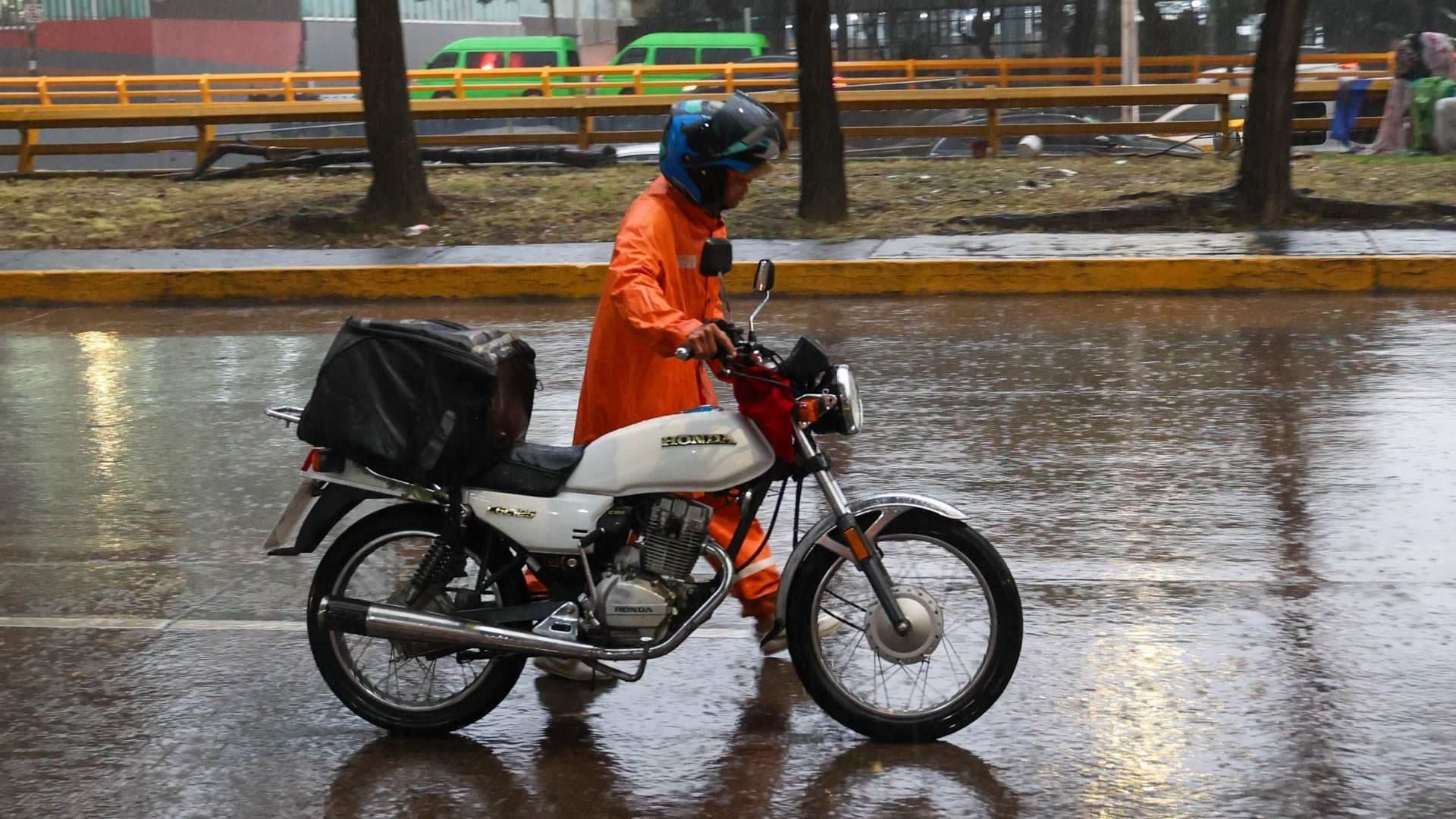 Hombre se protege de la lluvia con un impermeable en Circuito Interior, CDMX, el 19 de agosto 2026. Foto: Cuartoscuro | Archivo