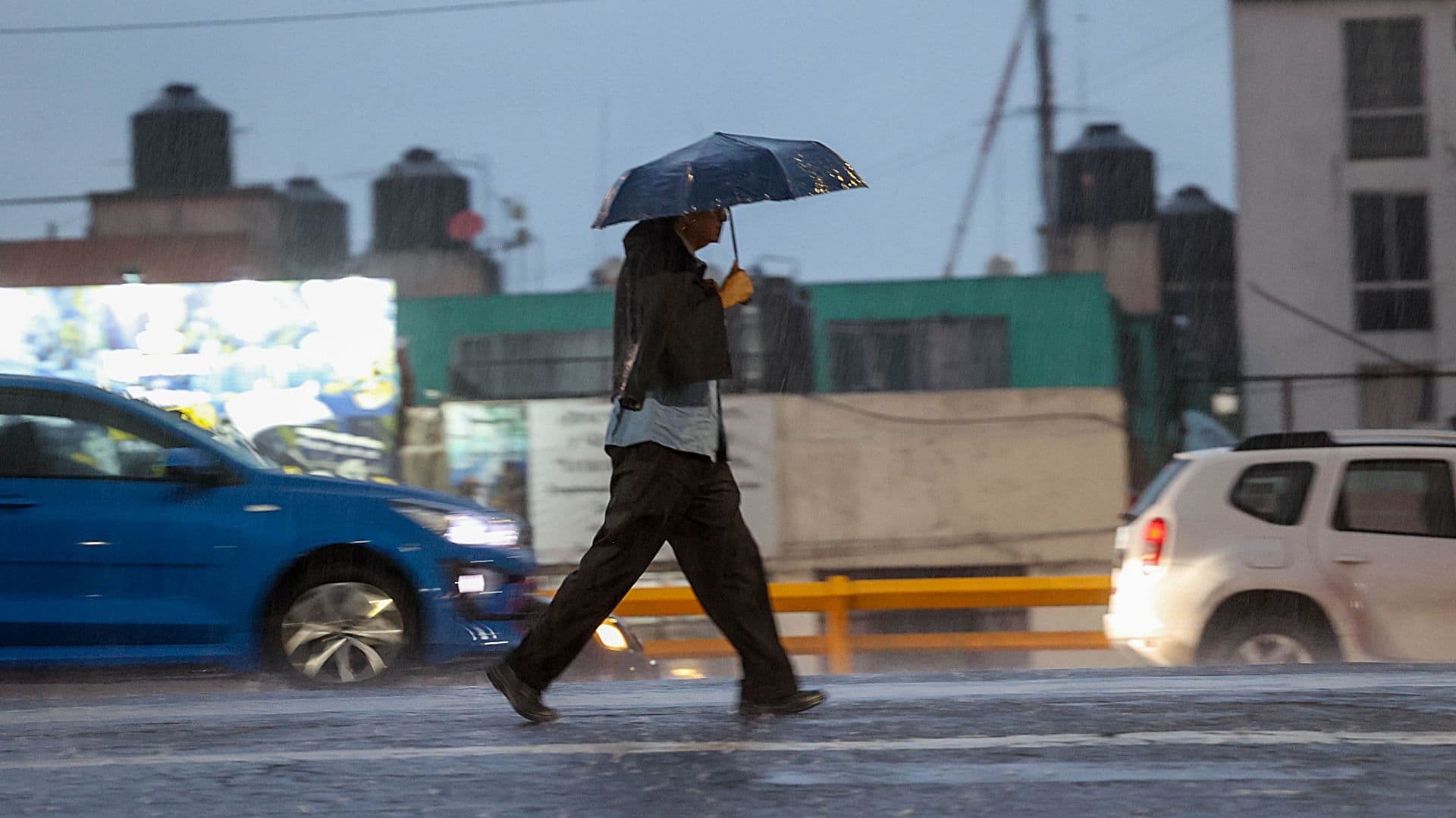 Hombre se protege con paraguas de la intensa lluvia en agosto 2026. Foto: Cuartoscuro | Archivo