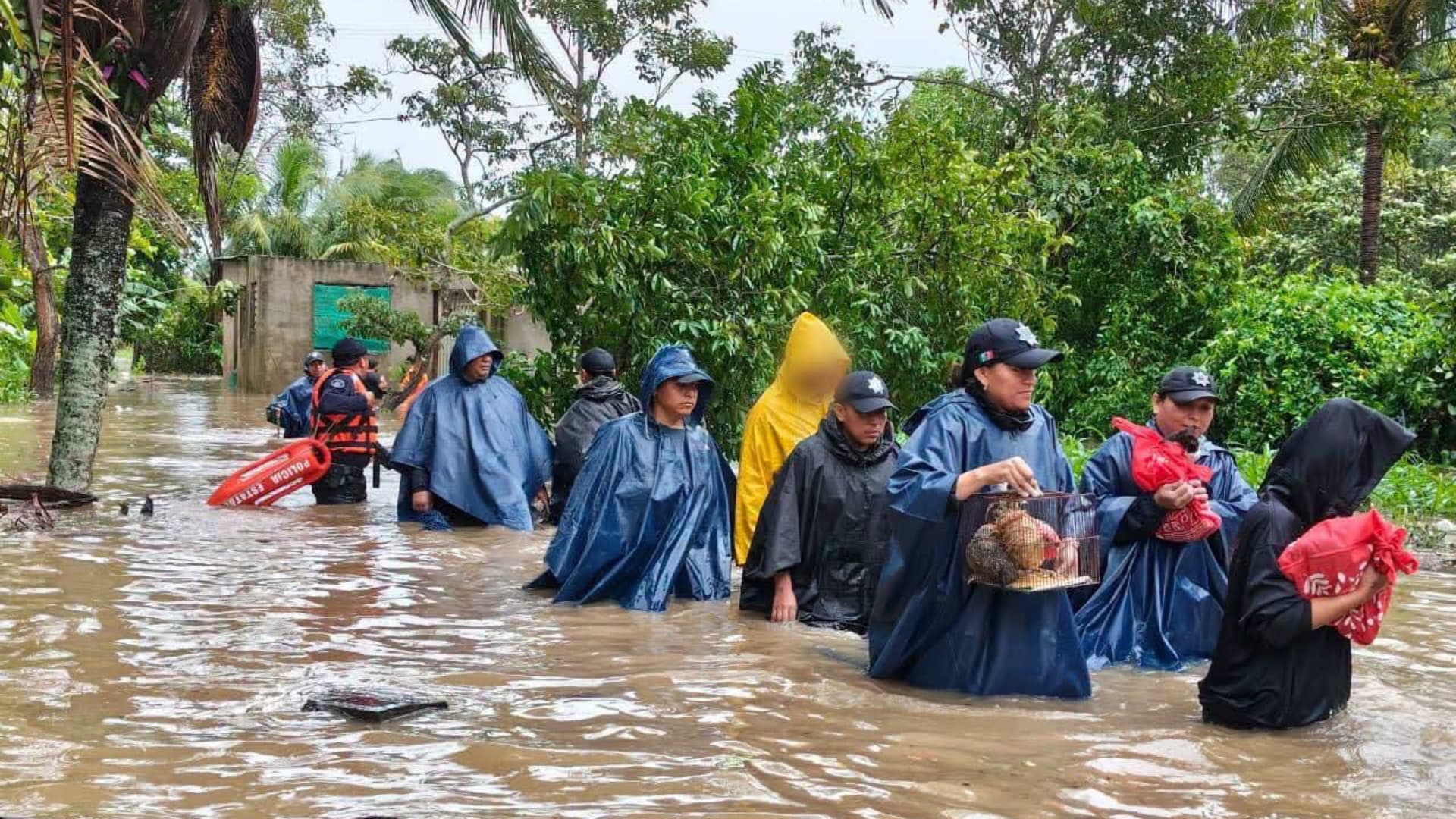 Personas caminan en medio de una inundación en Coatzacoalcos, Veracruz