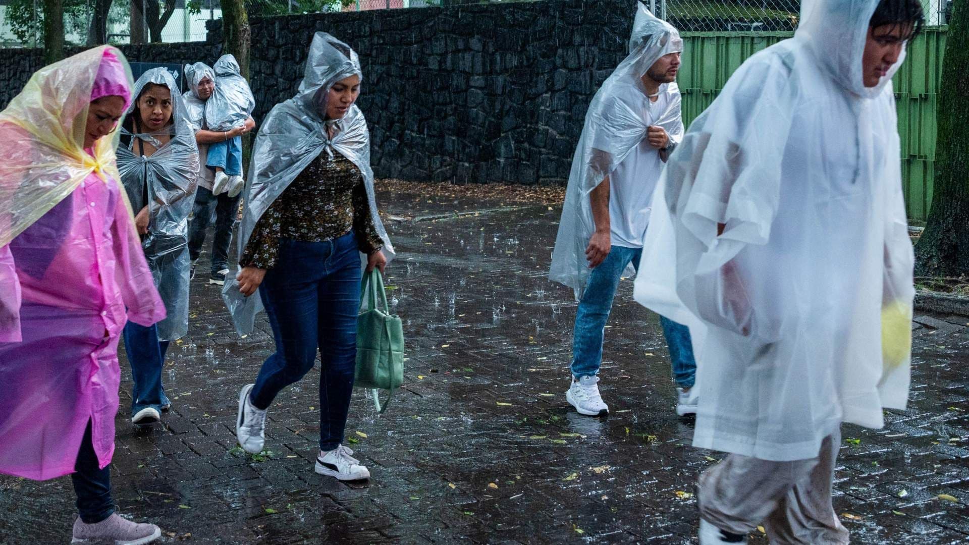 Personas se protegen con impermeables y paraguas ante intensa lluvia en CDMX el 22 de agosto 2026. Foto: Cuartoscuro