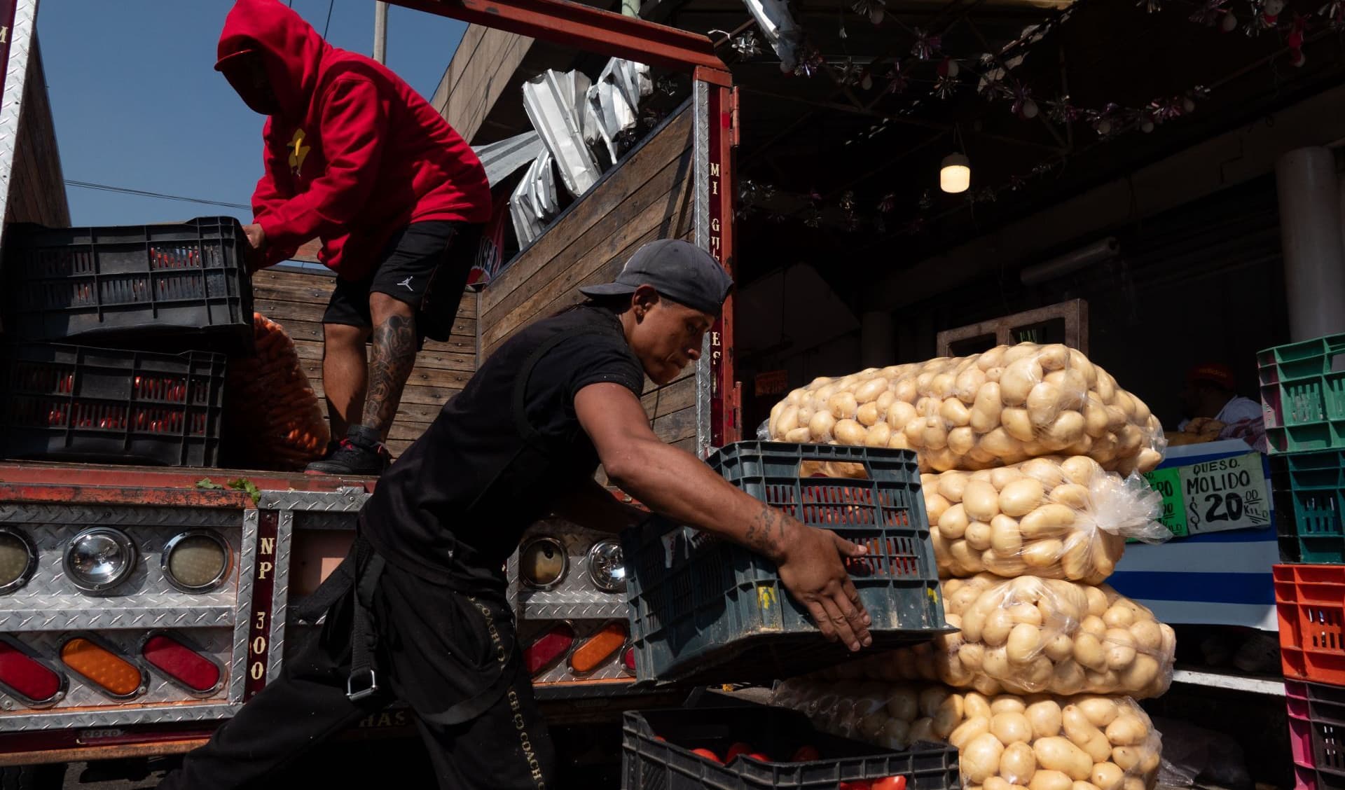 Trabajadores transportan verduras en el Mercado de la Merced.
