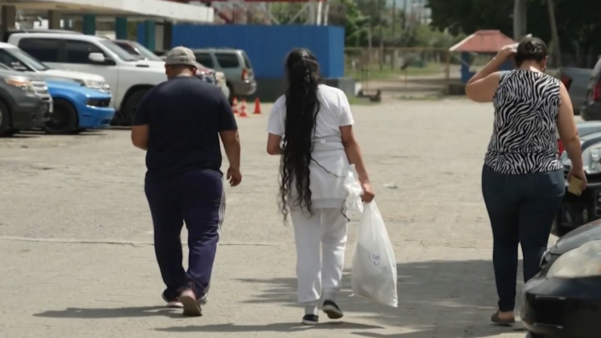 Una migrante deportada vestida con ropa blanca y calzado color negro.
