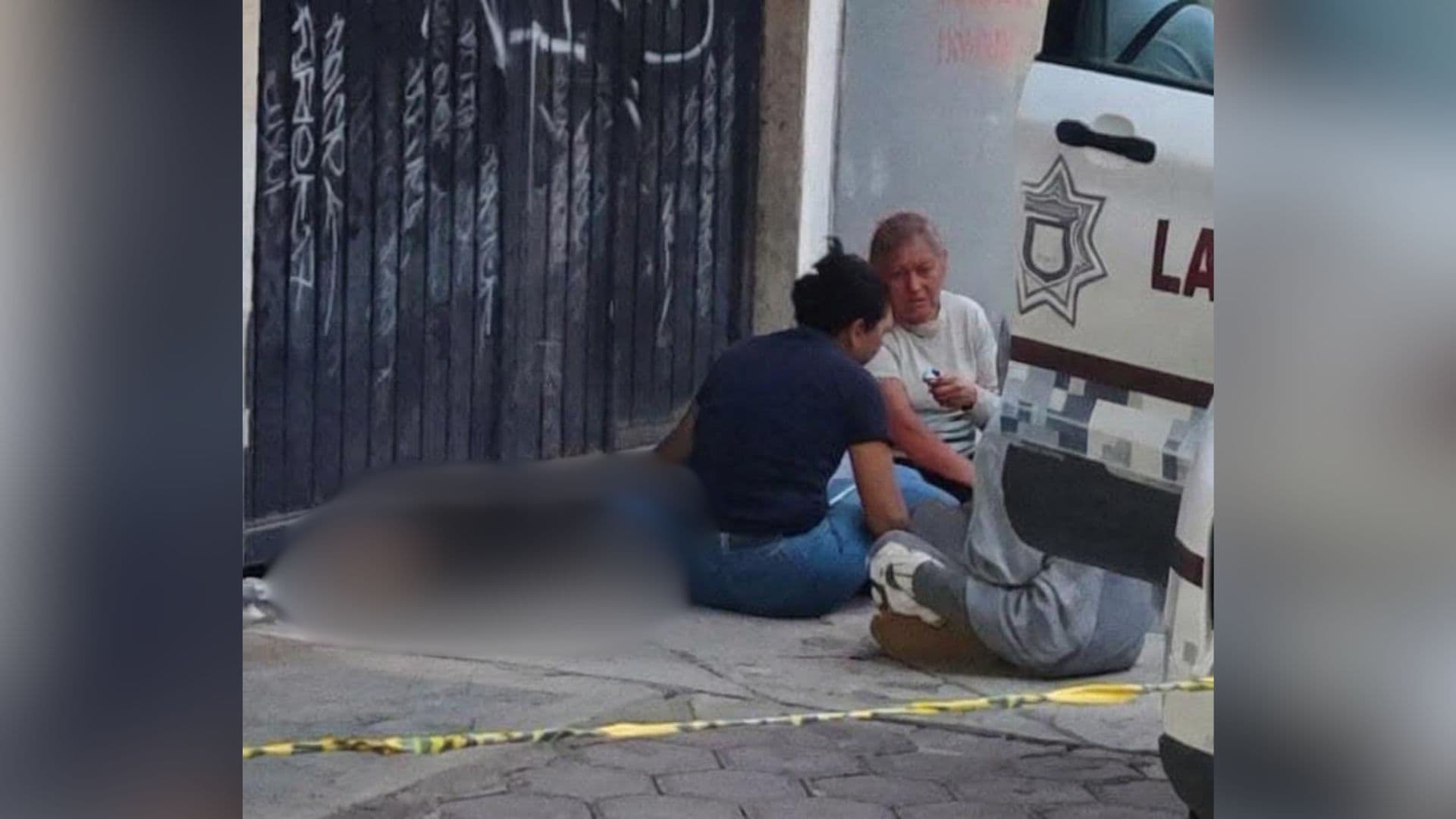 Tres personas se encontraban sentadas junto al cuerpo