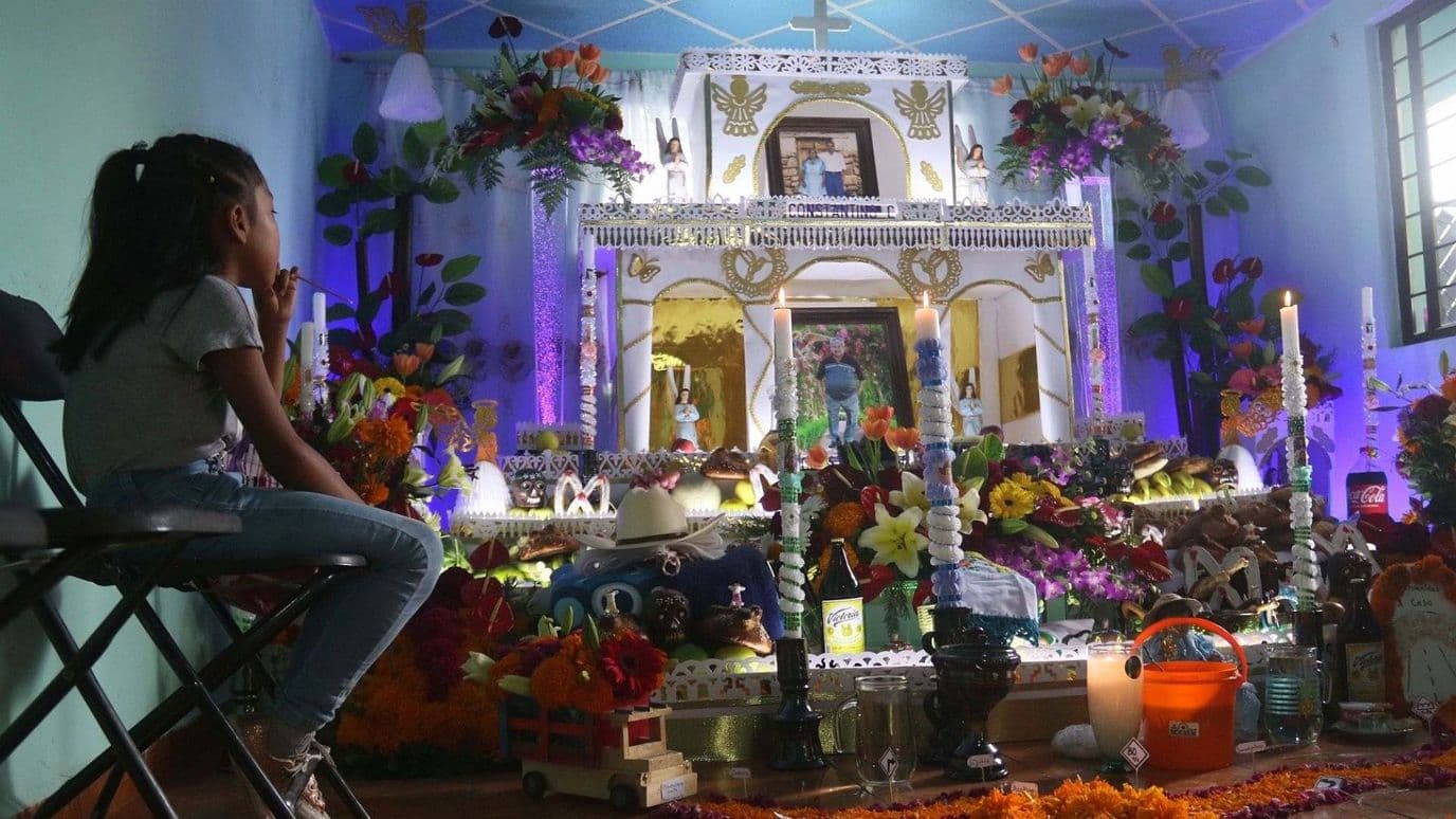 Niña Sentada frente a Altar de Muertos. Ofrenda Día de Muertos Primer Aniversario.