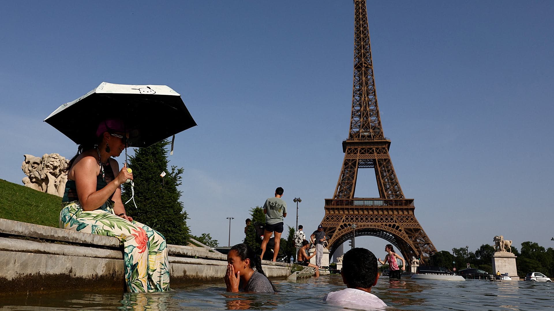 La gente se refresca en la fuente del Trocadero, frente a la Torre Eiffel, ante ola de calor en Francia, el 23 de junio de 2026. Foto: Reuters
