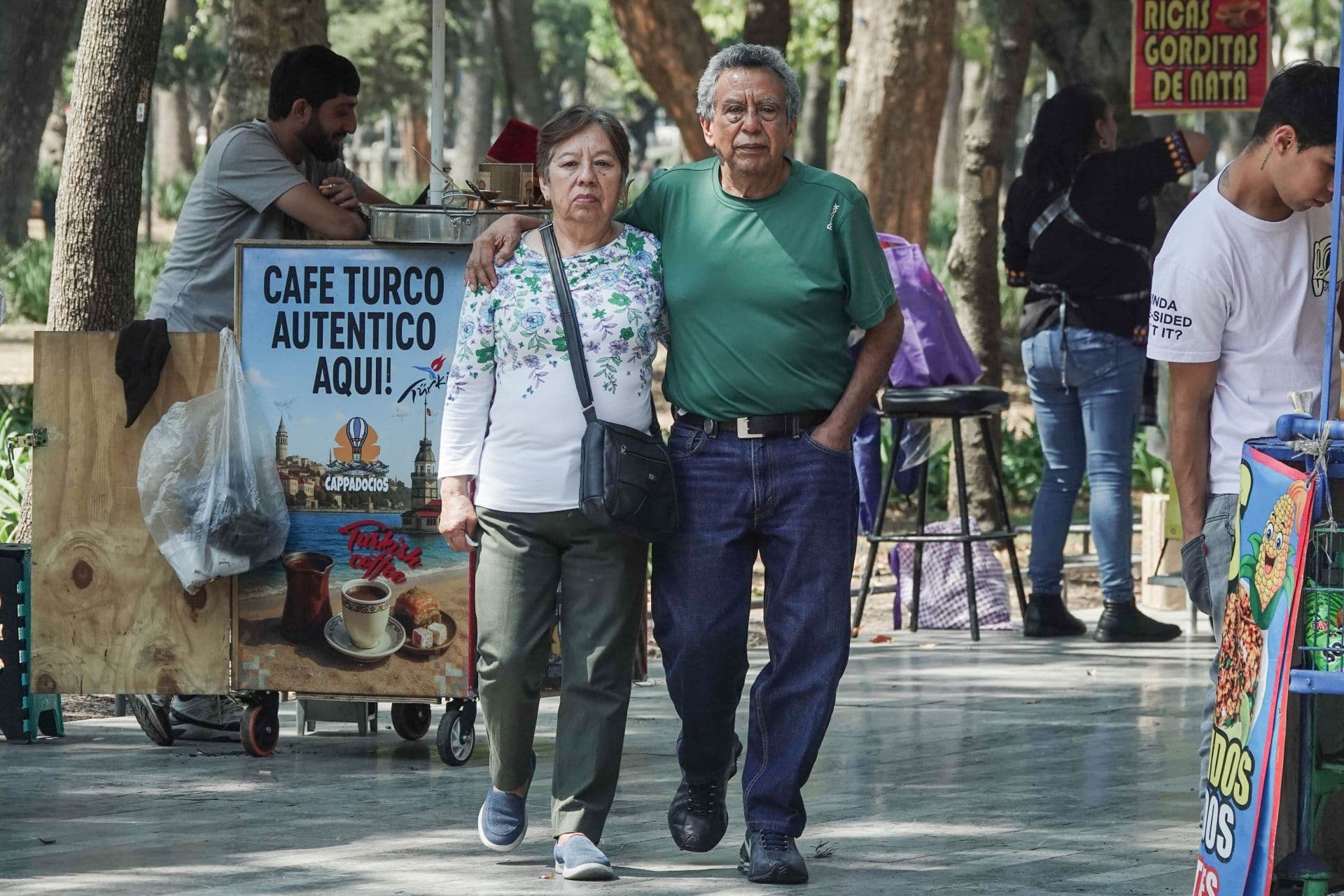 Adultos mayores caminan en parque