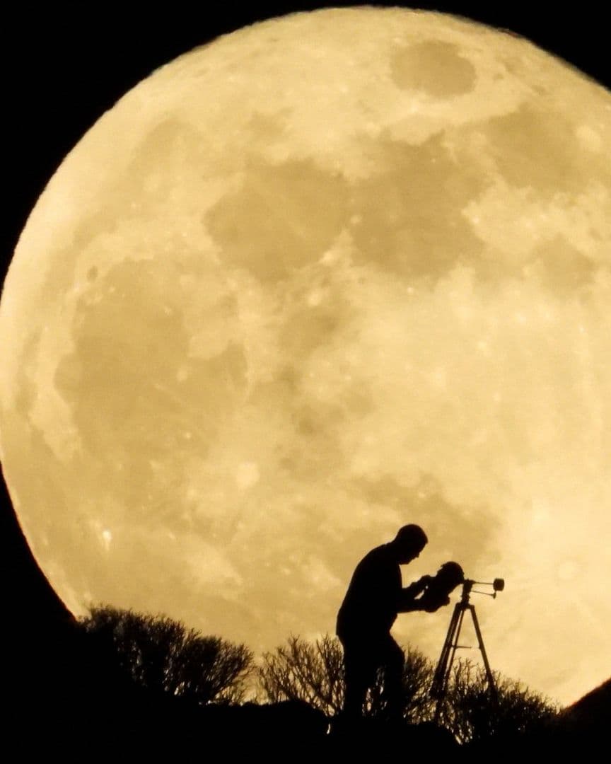 Personas con telescopio ante la Luna