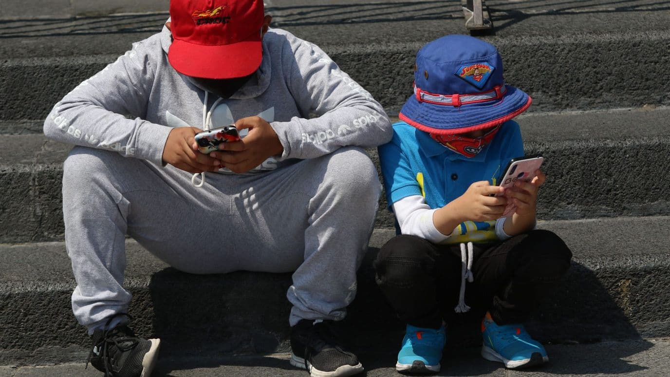 Niños se entretienen con sus respectivos celulares en CDMX. Foto: Cuartoscuro