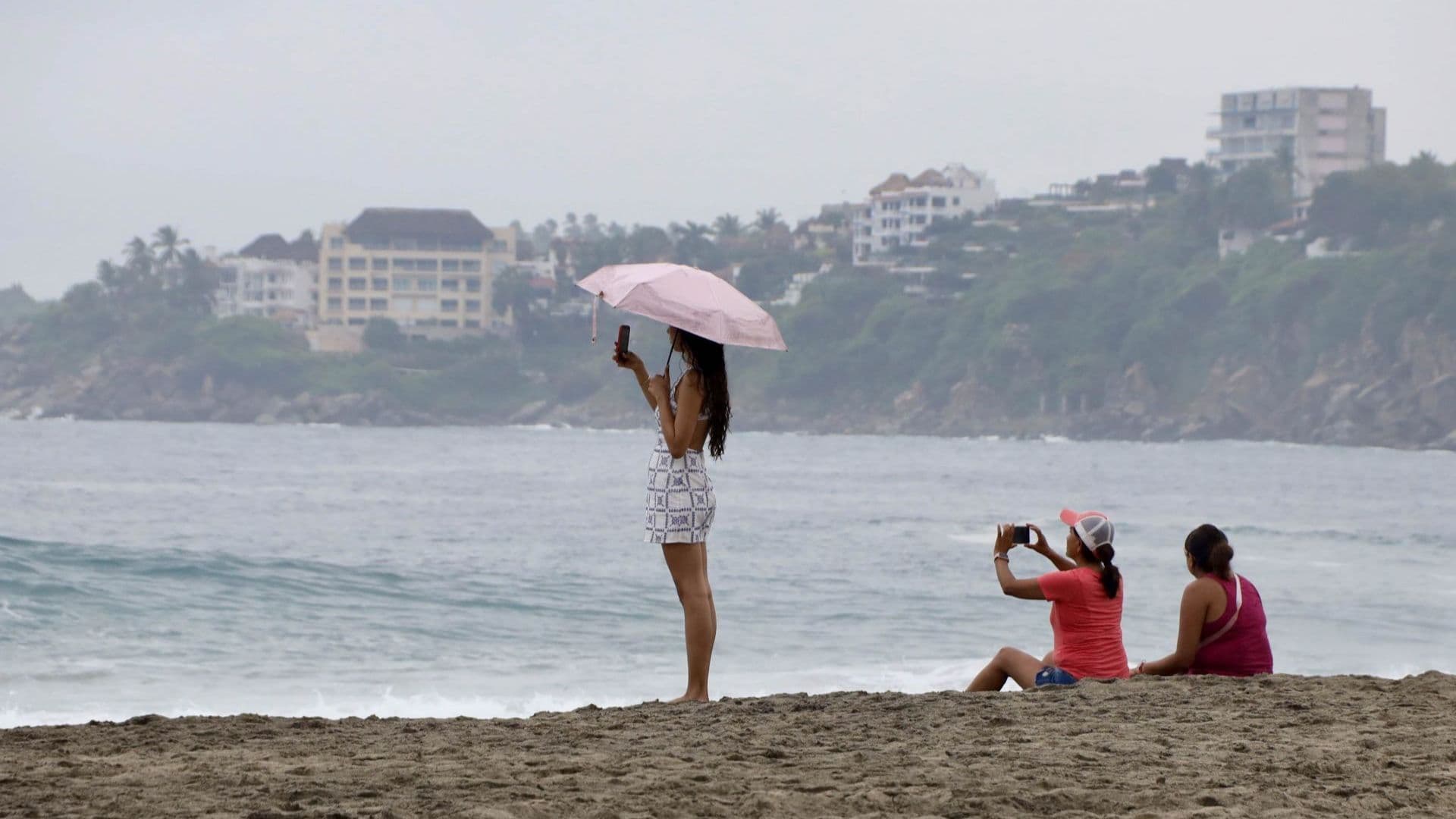 Algunas personas pasean por la Playa Zicatela en Oaxaca.