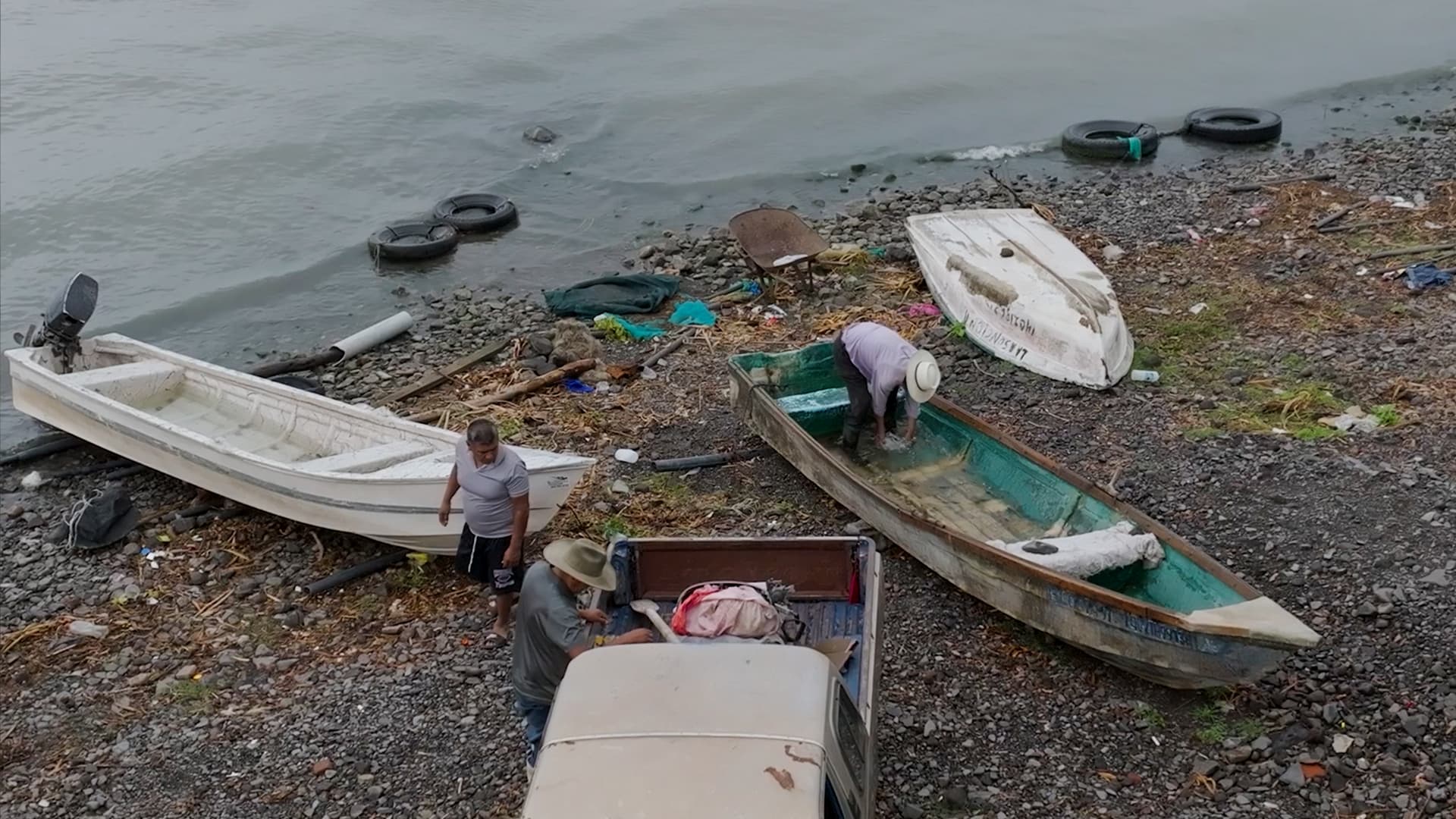 Pescadores viendo su pesca del dia a la orilla del lago