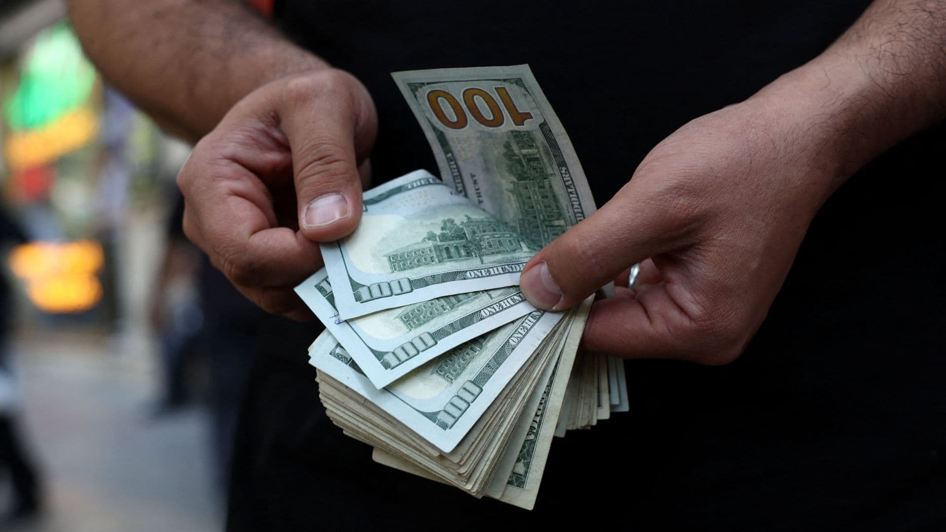 Un hombre cuenta billetes de 100 dólares