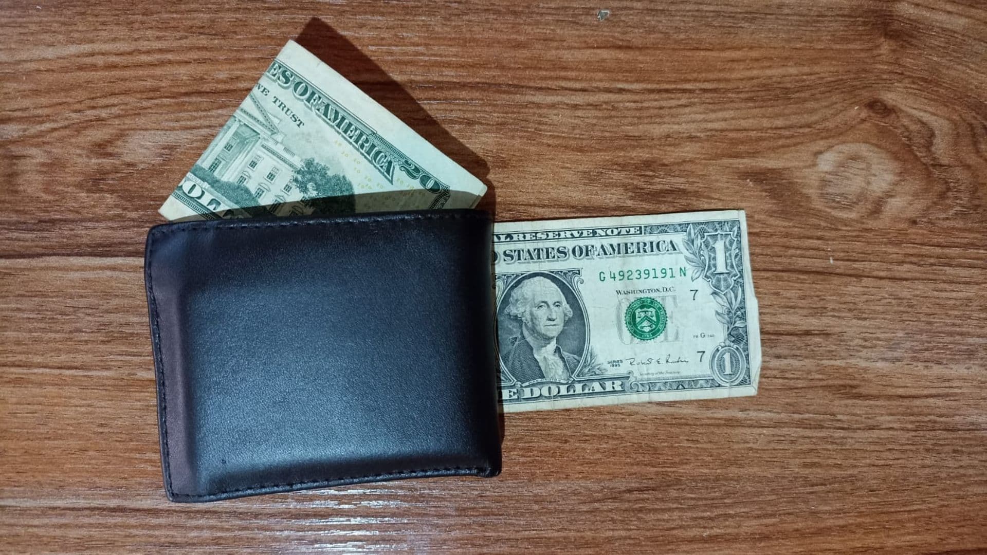 Billetes de 20 y un dólar estadounidense en una cartera