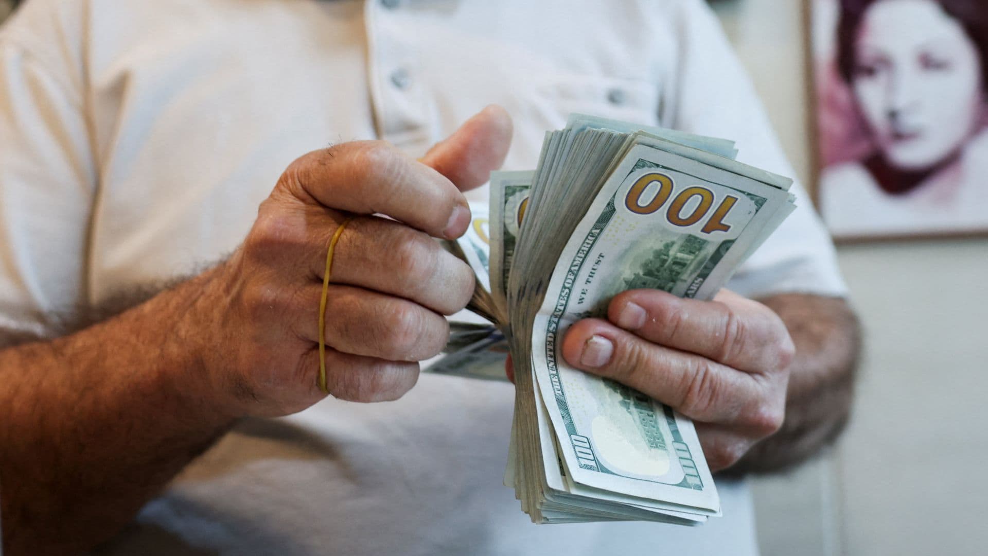 Un hombre cuenta billetes de 100 dólares
