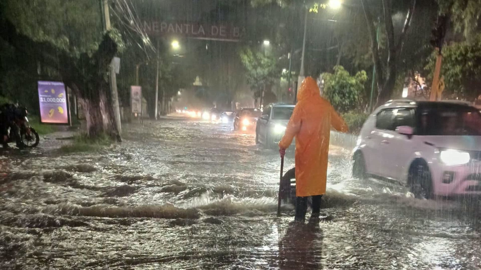 Un elementos de Protección Civil de Tlalnepantla intenta drenar una inundación