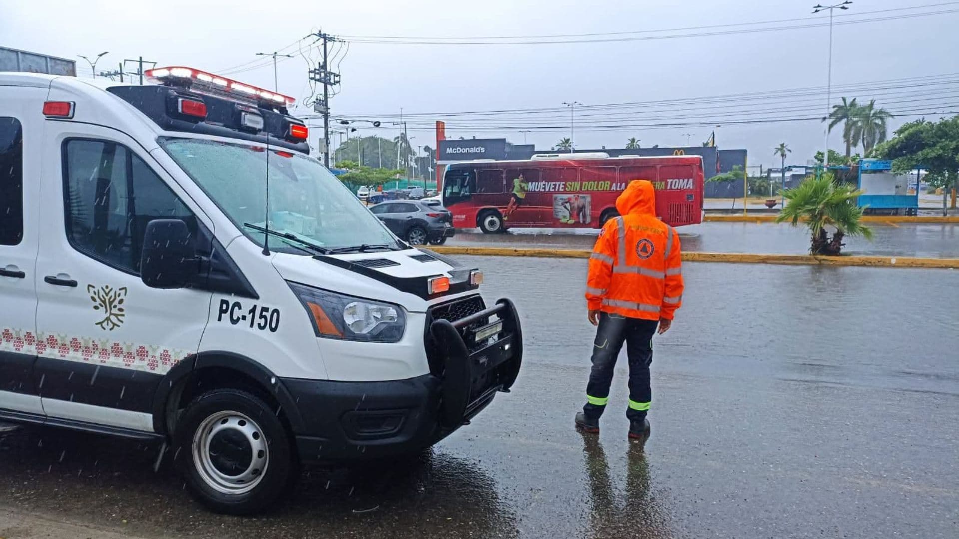 Un elemento de Protección Civil de Acapulco vigila el tránsito tras las fuertes lluvias en el puerto