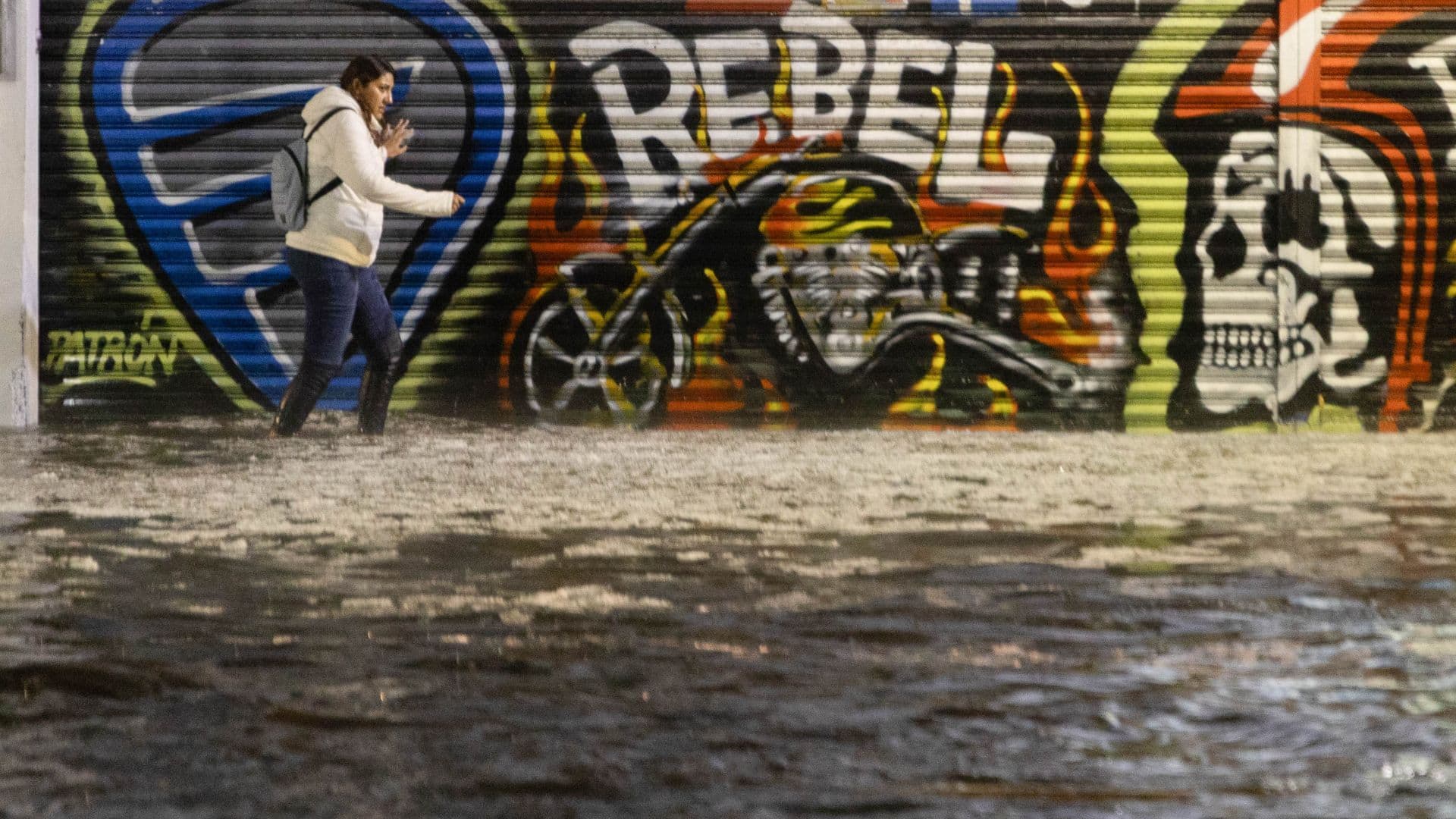 Una joven camina en medio de una inundación en la alcaldía Iztacalco, en la CDMX