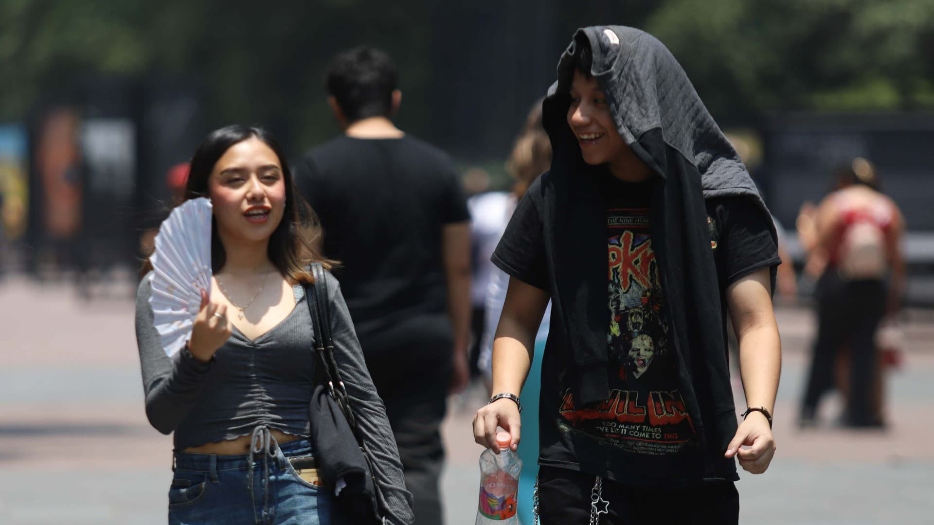 Una mujer y un hombre intentan contrarrestar el calor de la CDMX