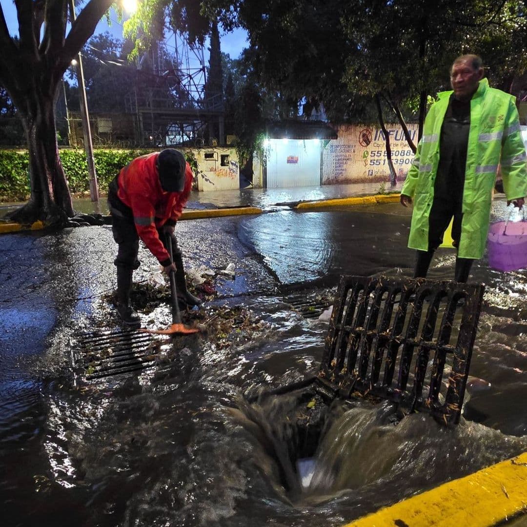 Elementos de equipos de emergencia ayudan a destapar alcantarillado en la CDMX