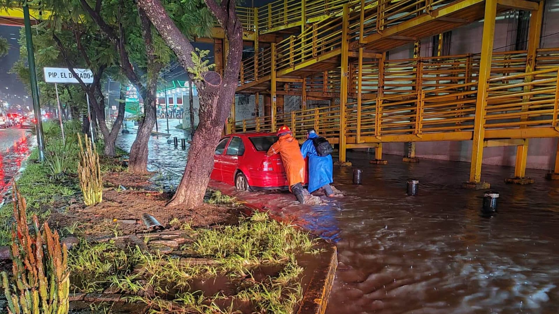 Elementos de Protección Civil de Michoacán ayudan a un conductor varado por las inundaciones en Morelia