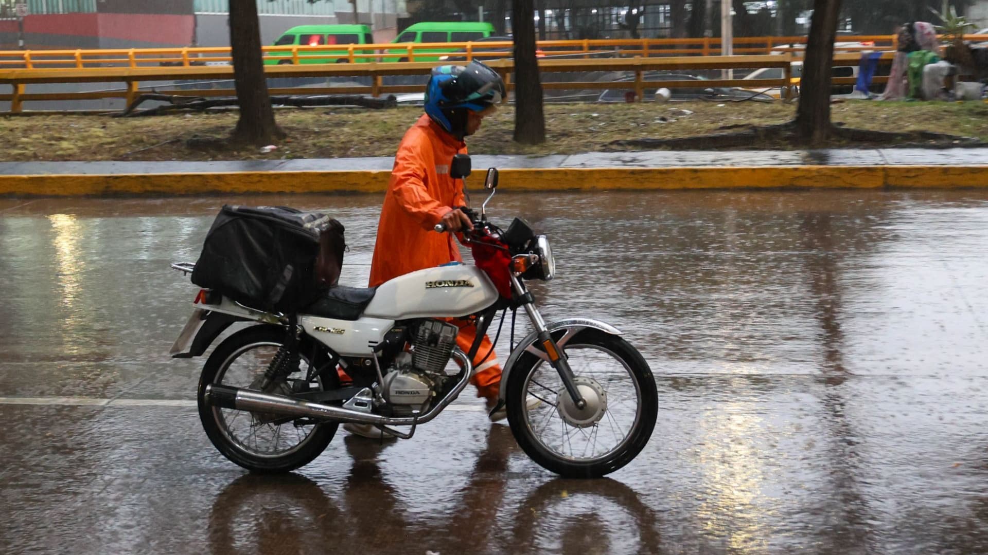 Un motociclista camina con su vehículo averiado en la CDMX