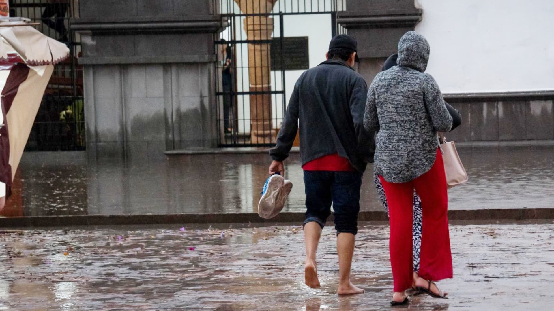 Dos personas caminan por una calle inundada en Tlaxcala