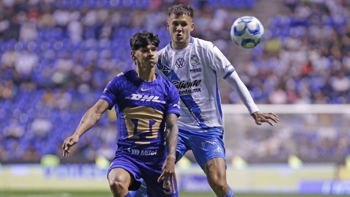 Robert Morales, delantero de Pumas, disputa un balón con el defensa poblano Juan Pablo Vargas en el Estadio Cuauhtémoc.