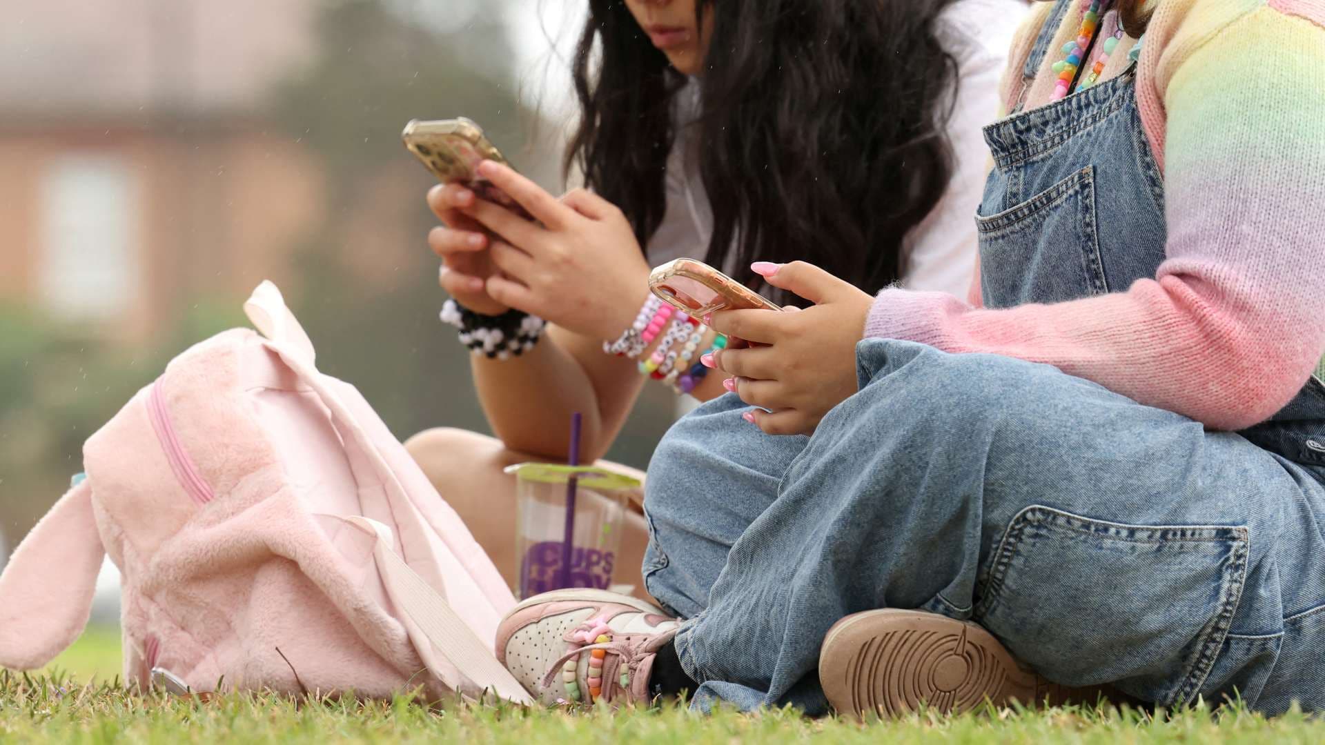 Dos adolescentes usan sus teléfonos luego de la prohibición de redes sociales para menores en Australia. Foto: Reuters | Archivo