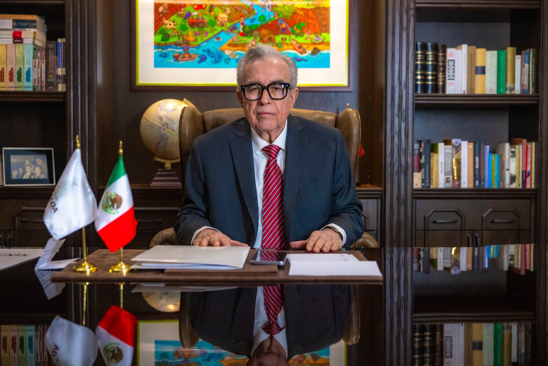 Rubén Rocha Moya sentado detrás de escritorio, vistiendo traje y corbata