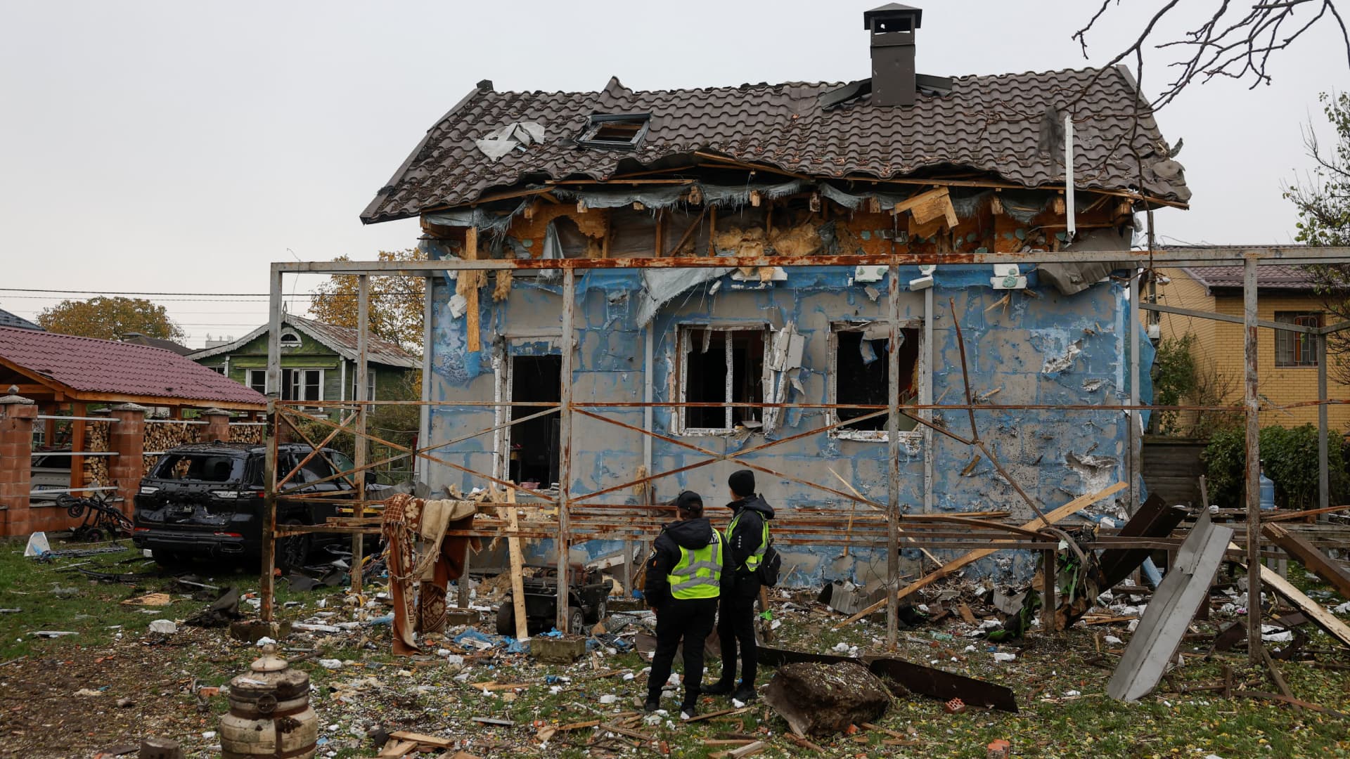 Policías observan una casa dañada en Kiev