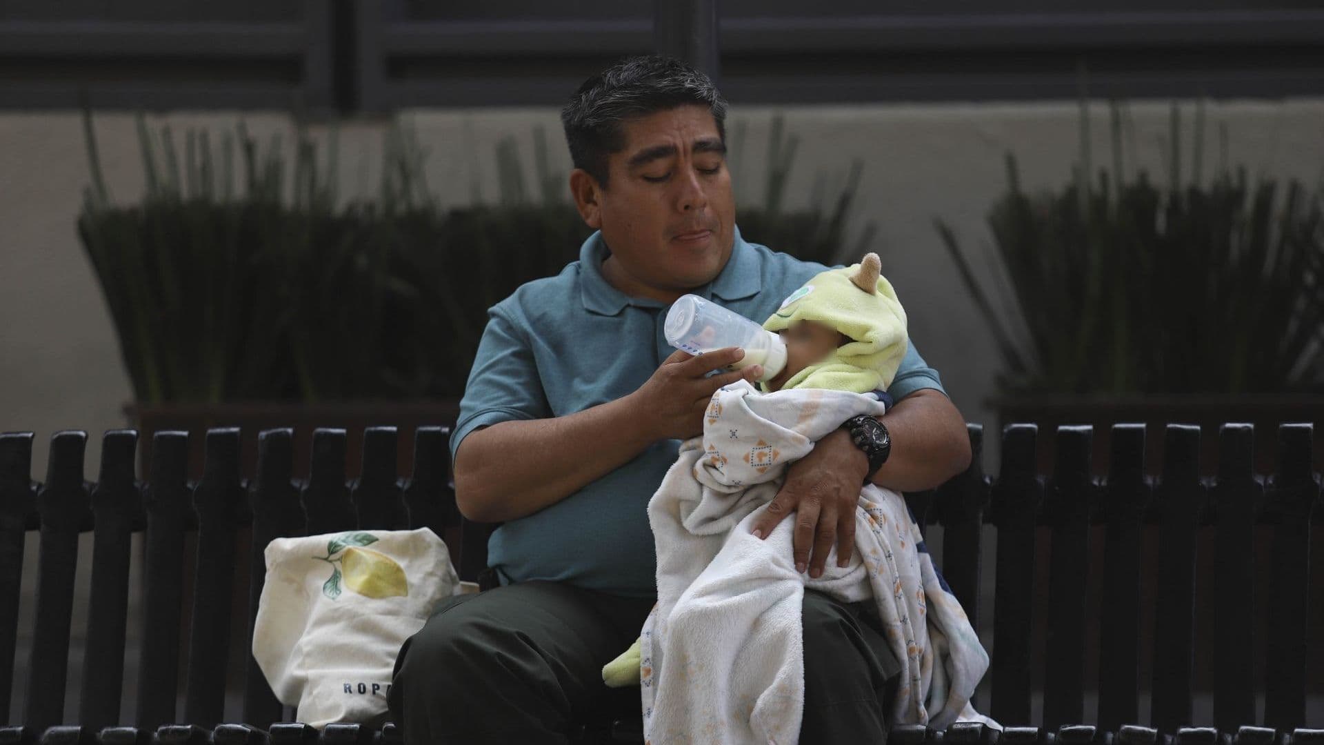 Un señor alimenta a un bebé