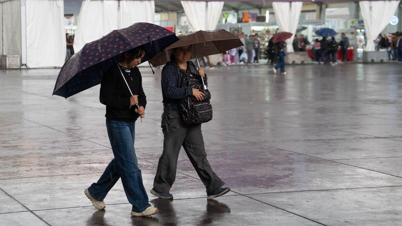 Dos mujeres caminan durante una tarde lluviosa en la zona centro de la CDMX