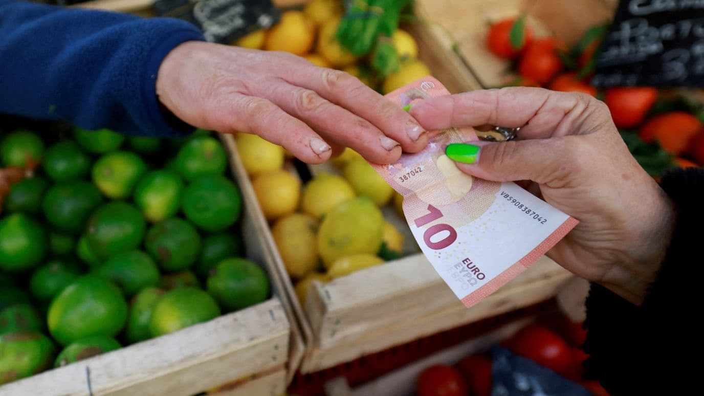 A shopper pays with a ten Euro bank note at a local market in Aix-en-Provence, France