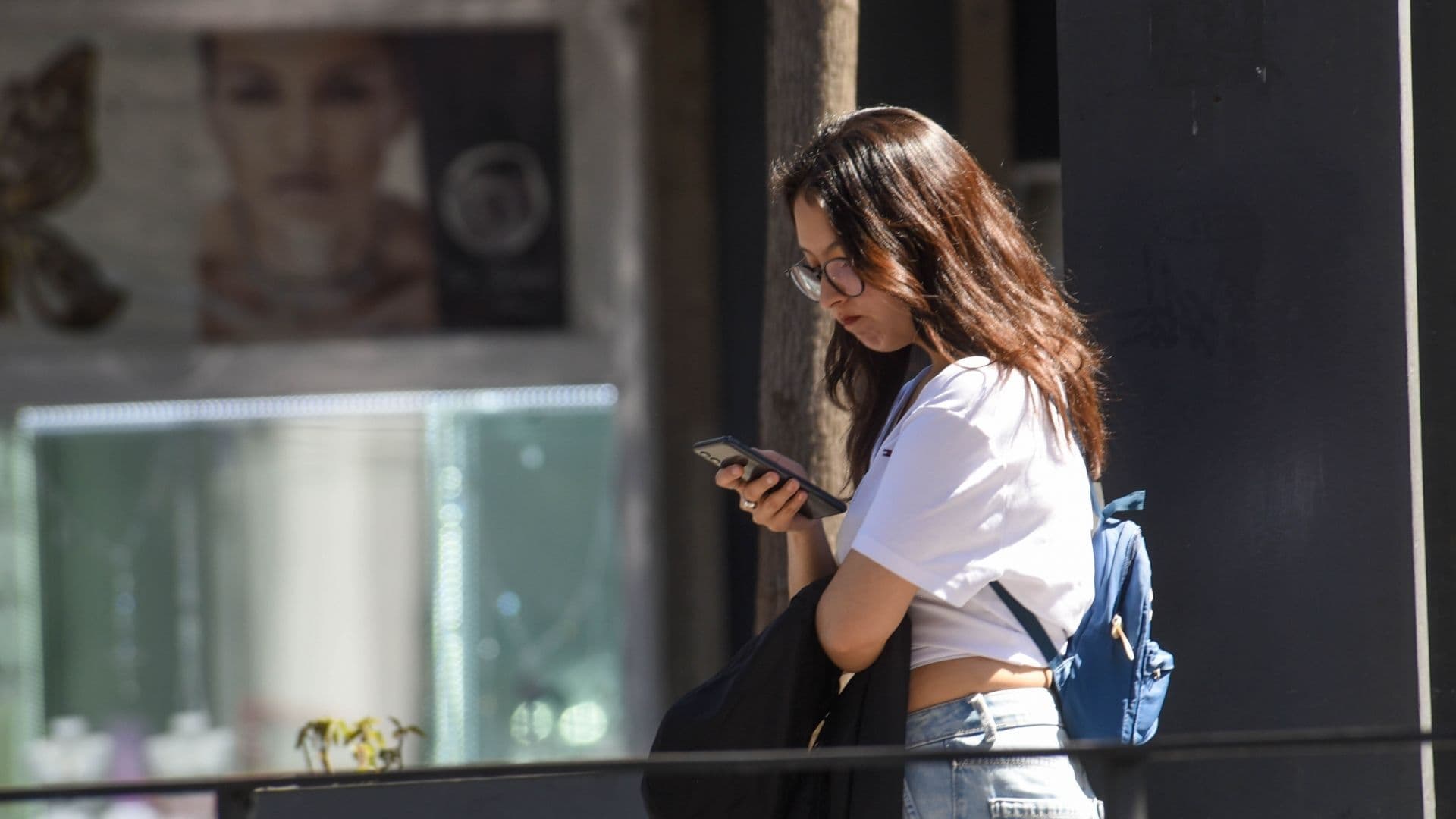 Una joven usando su celular