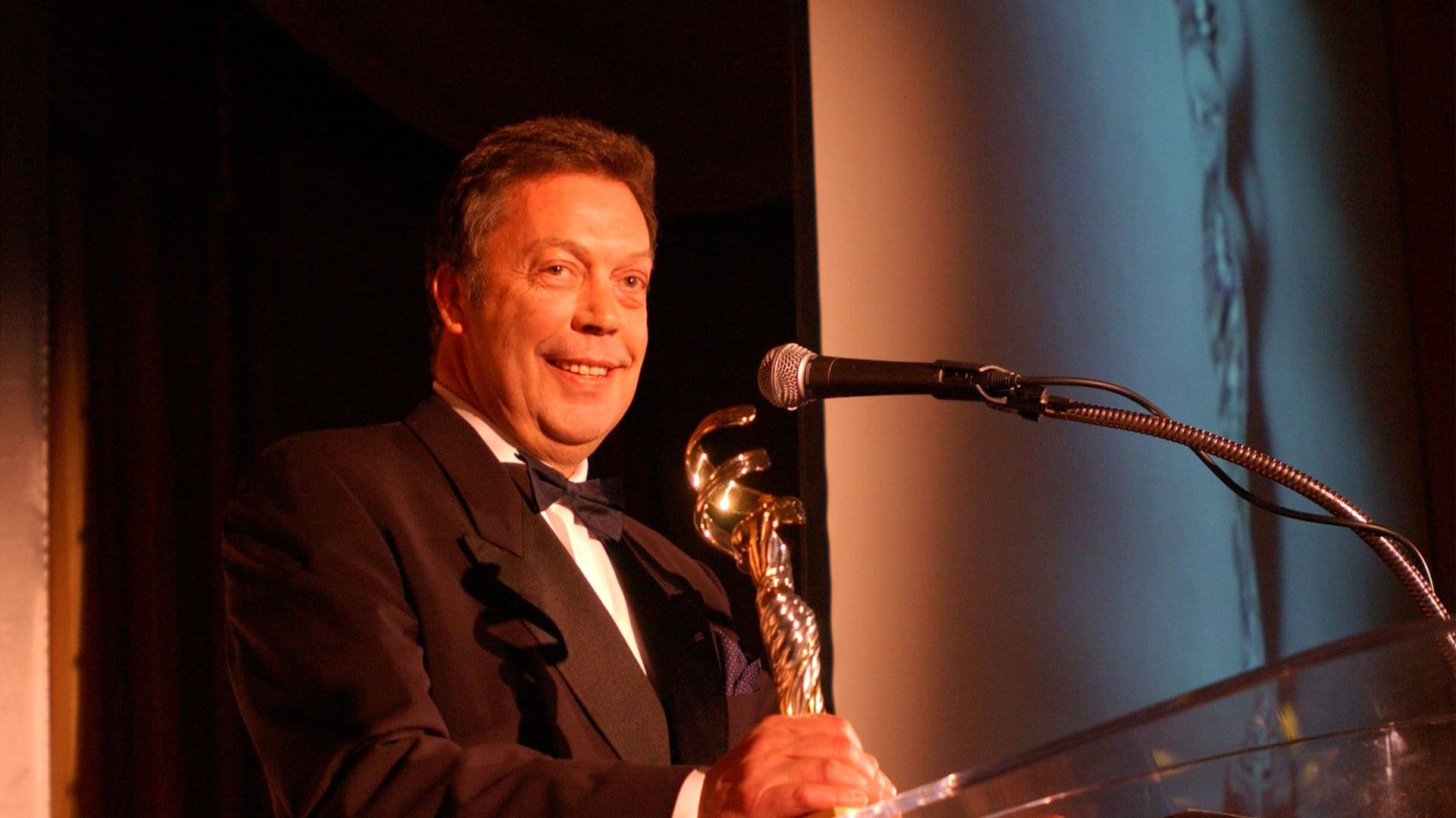 Tim Curry sostiene estatuilla en la cuarta edición de los Premios del Gremio de Diseñadores de Vestuario, en el Hotel Beverly Hills