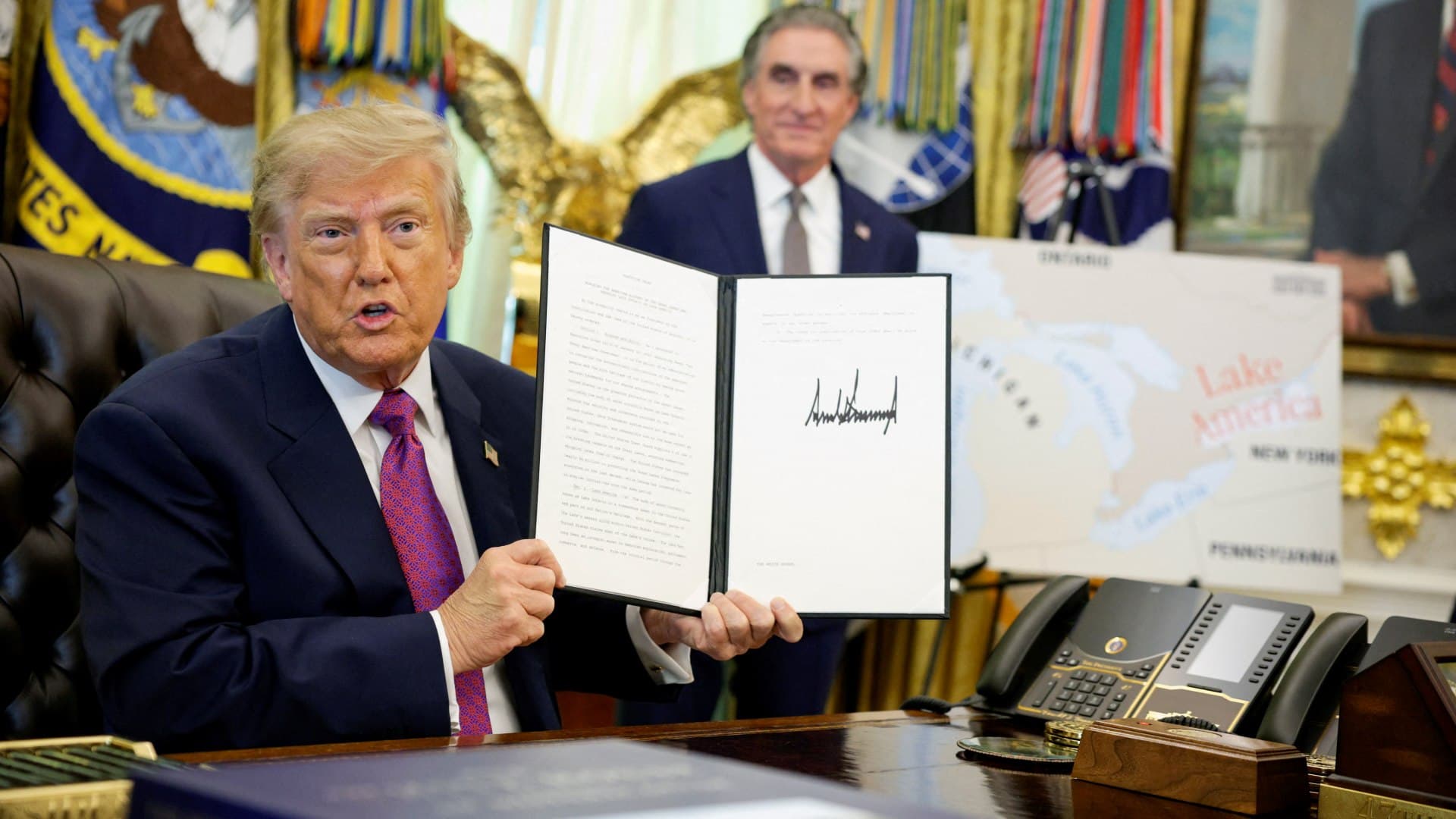 Trump muestra una orden ejecutiva que firmó en la Casa Blanca para cambiar el nombre del lago Ontario a lago América. Foto: Reuters