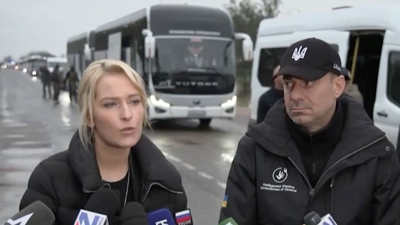 Yana Lantratova y Dmytro Lubinets hablan con periodistas frente a un convoy de ayuda humanitaria