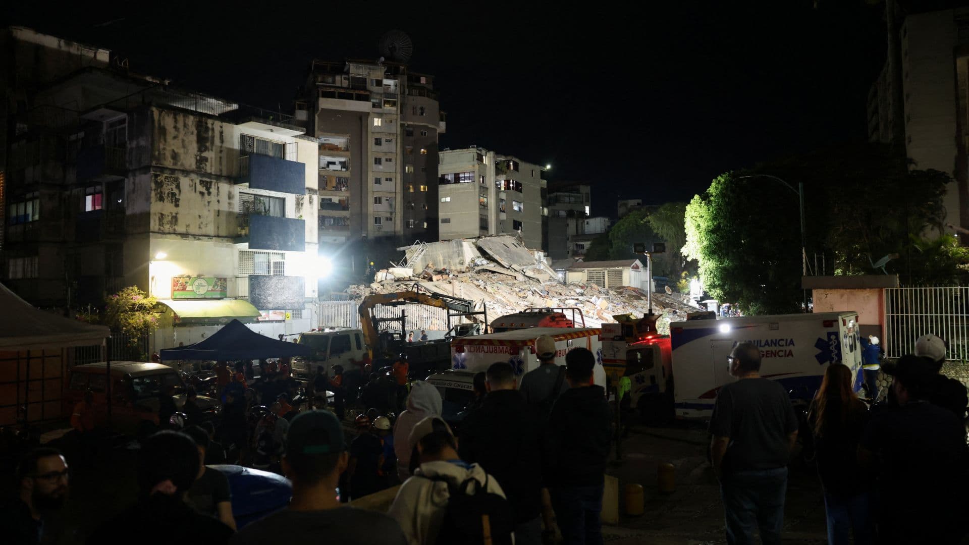 Servicios de emergencia laboran en el lugar de un edificio colapsado tras los terremotos en Venezuela.