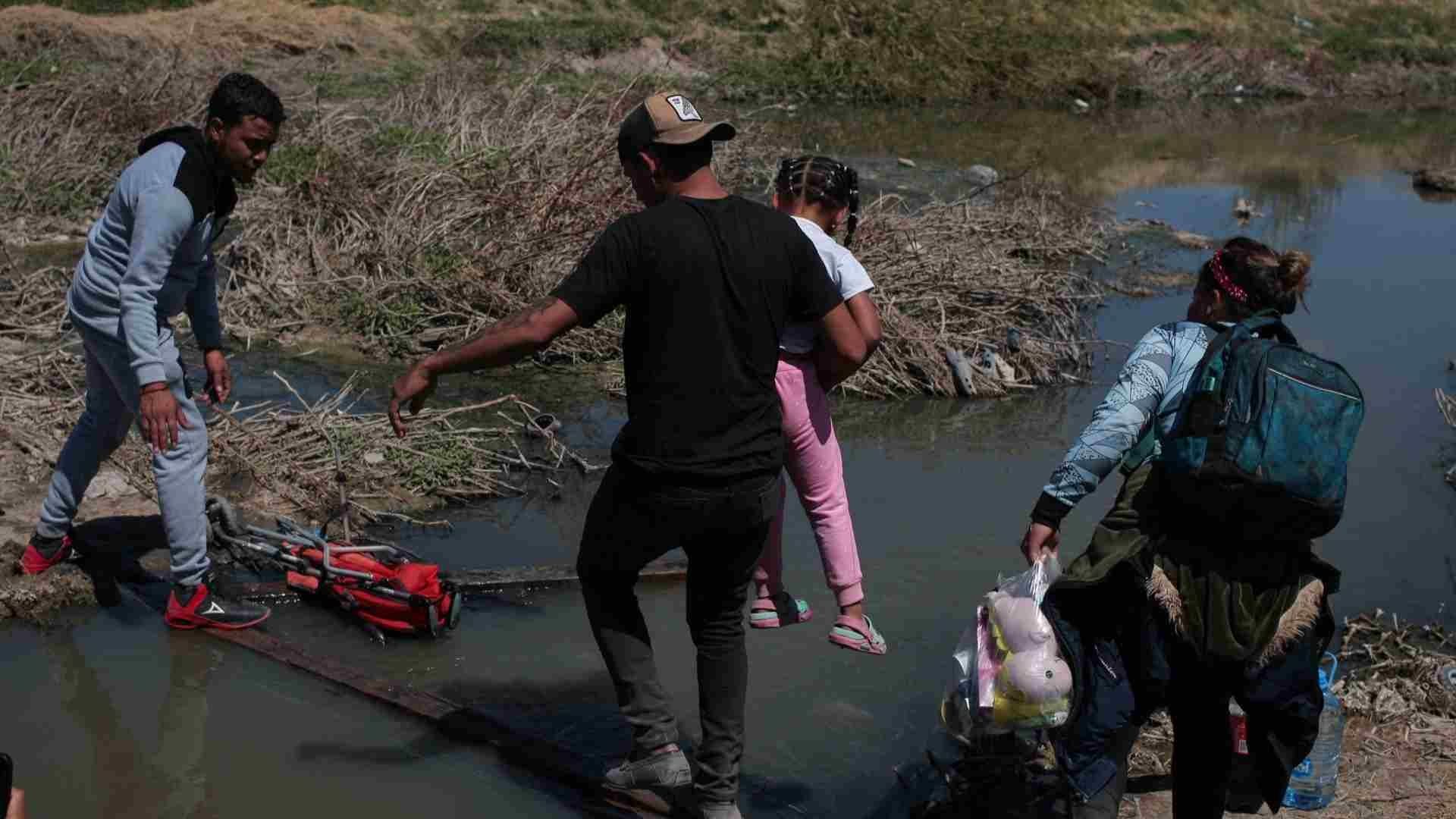 Migrantes cruzan por el río Bravo.