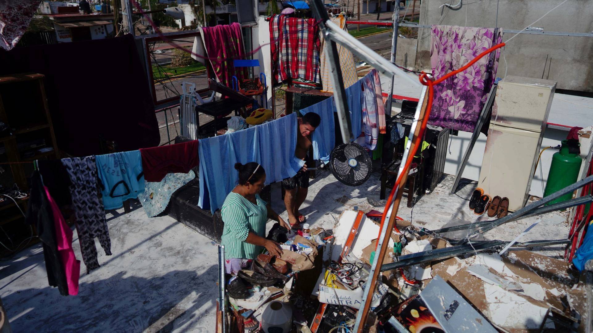 La profesora Roxana Guerrero y Jesús Rojas revisan los daños que el huracán Otis dejó en su casa. 