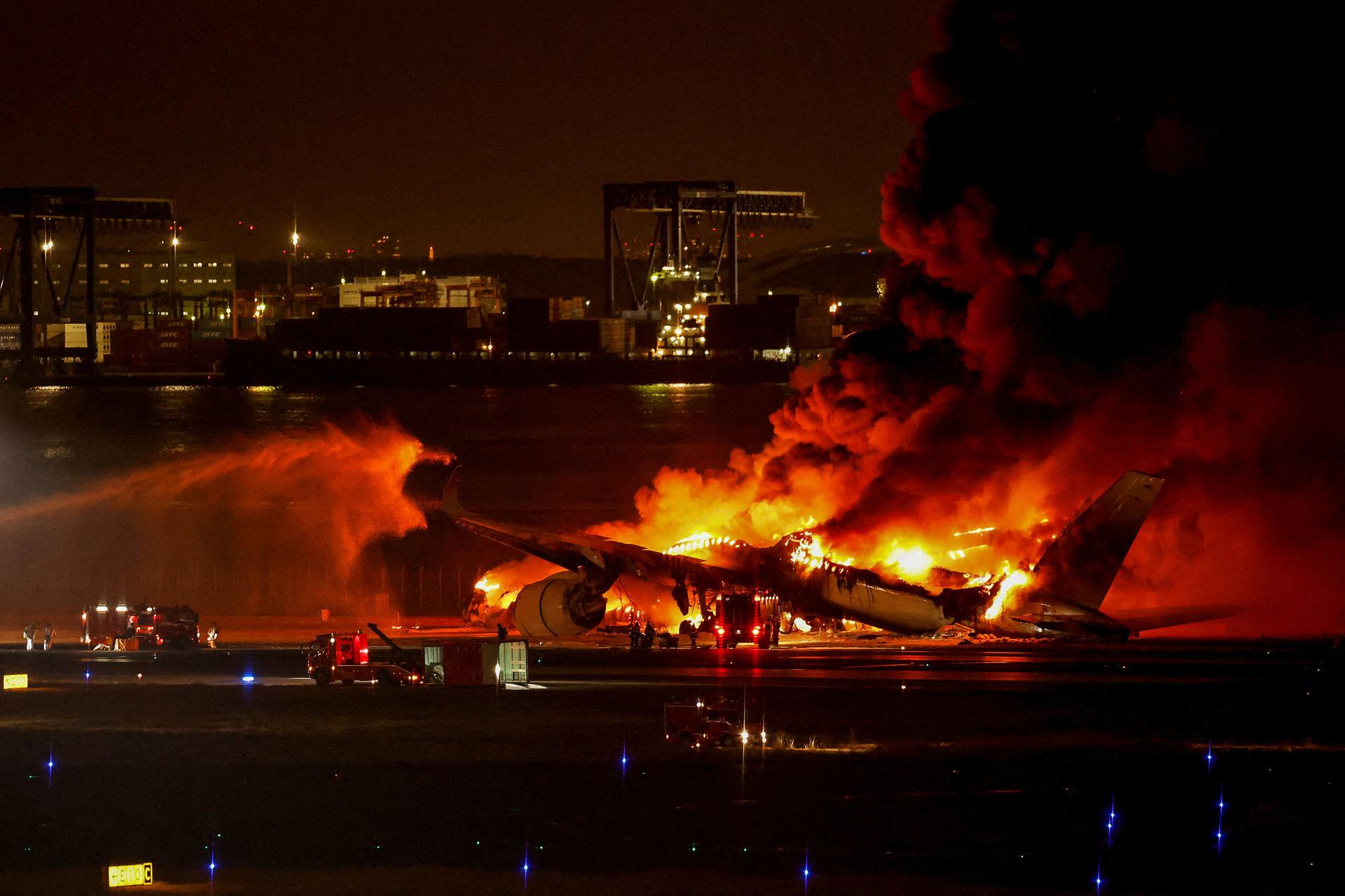 Bomberos apagan un avión incendiado en el Aeropuerto Internacional de Haneda en Tokio