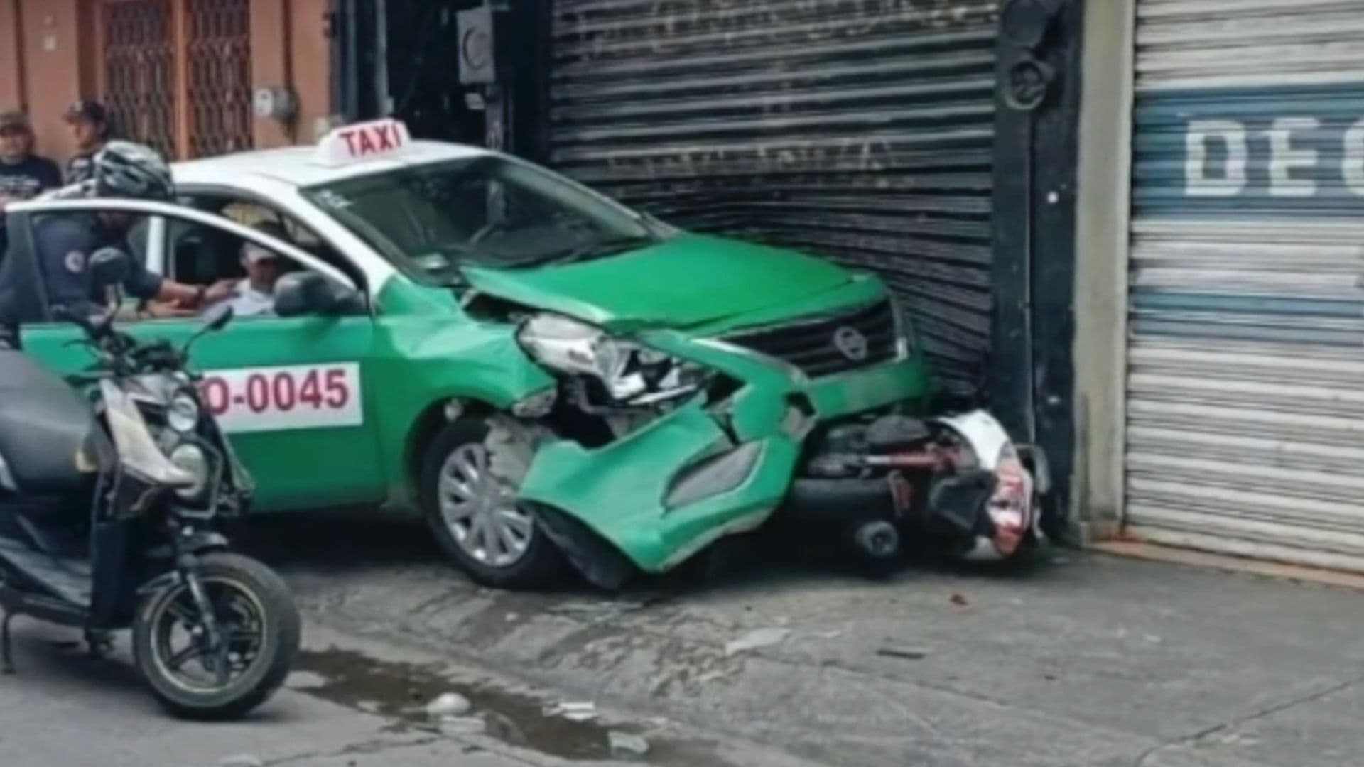 Taxista Sufre Preinfarto al Volante; Choca Contra una Moto y un Comercio de Ropa en Moroleón