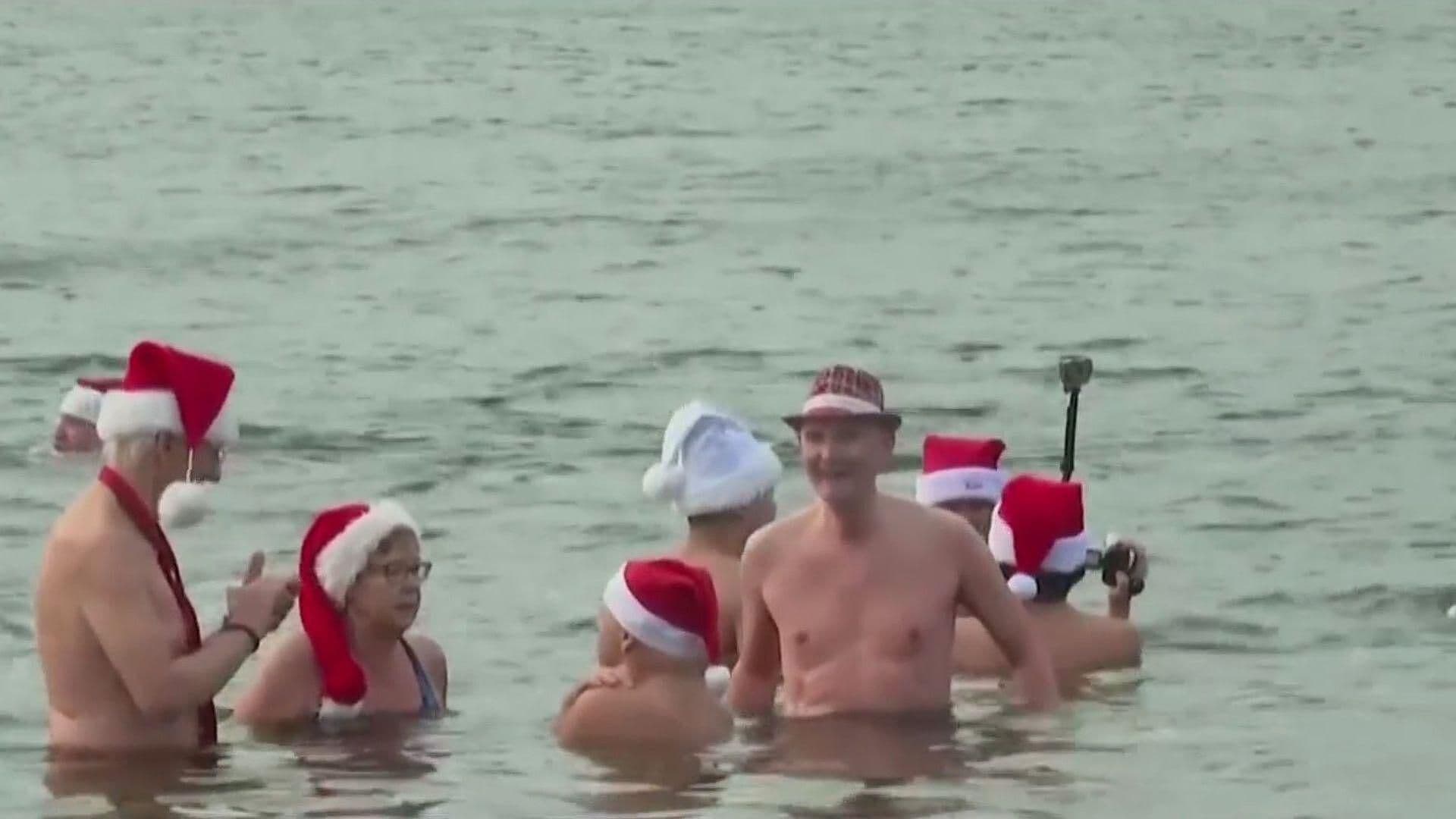 Disfrutan Chapuzón en Lago Helado con Todo y Gorro de Santa